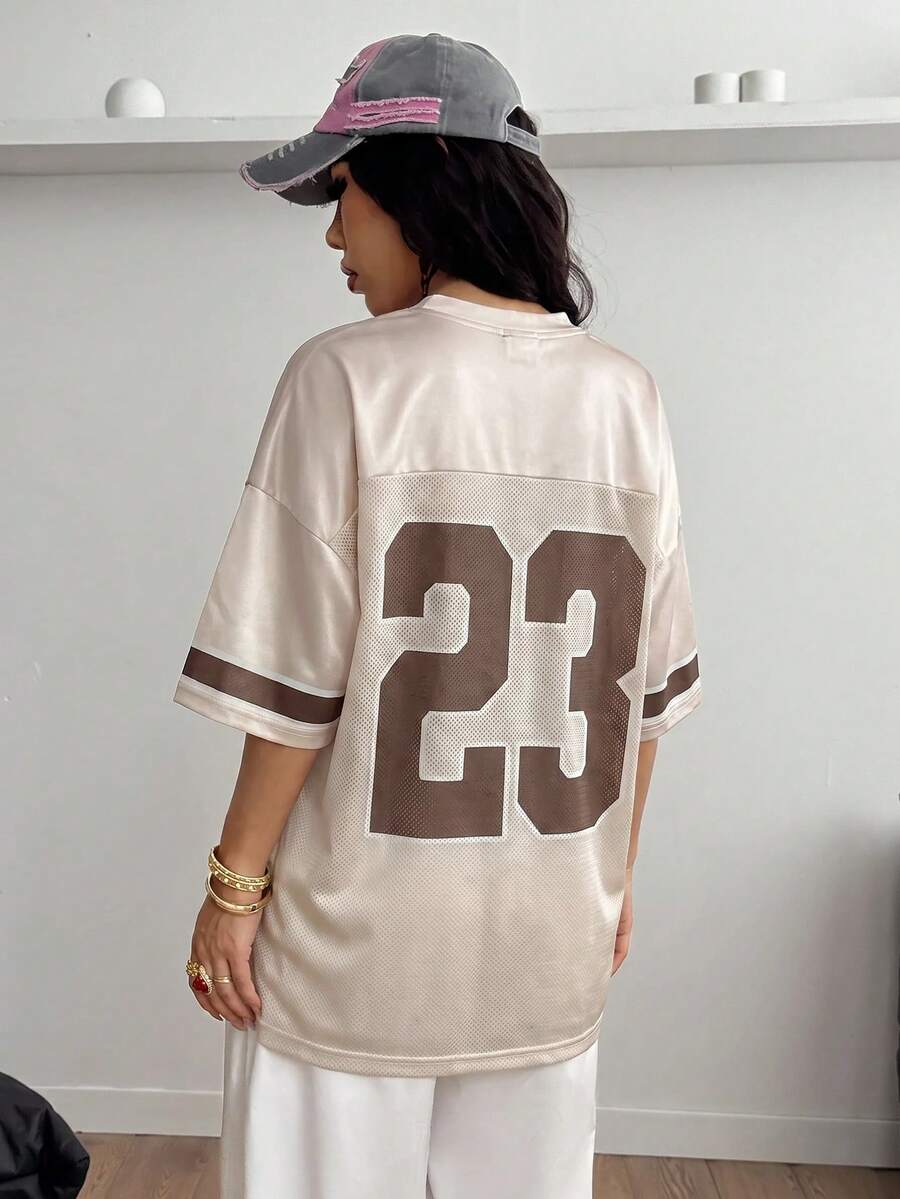 Oversized short-sleeve football jersey top featuring a V-neckline, contrast binding, and graphic number print.