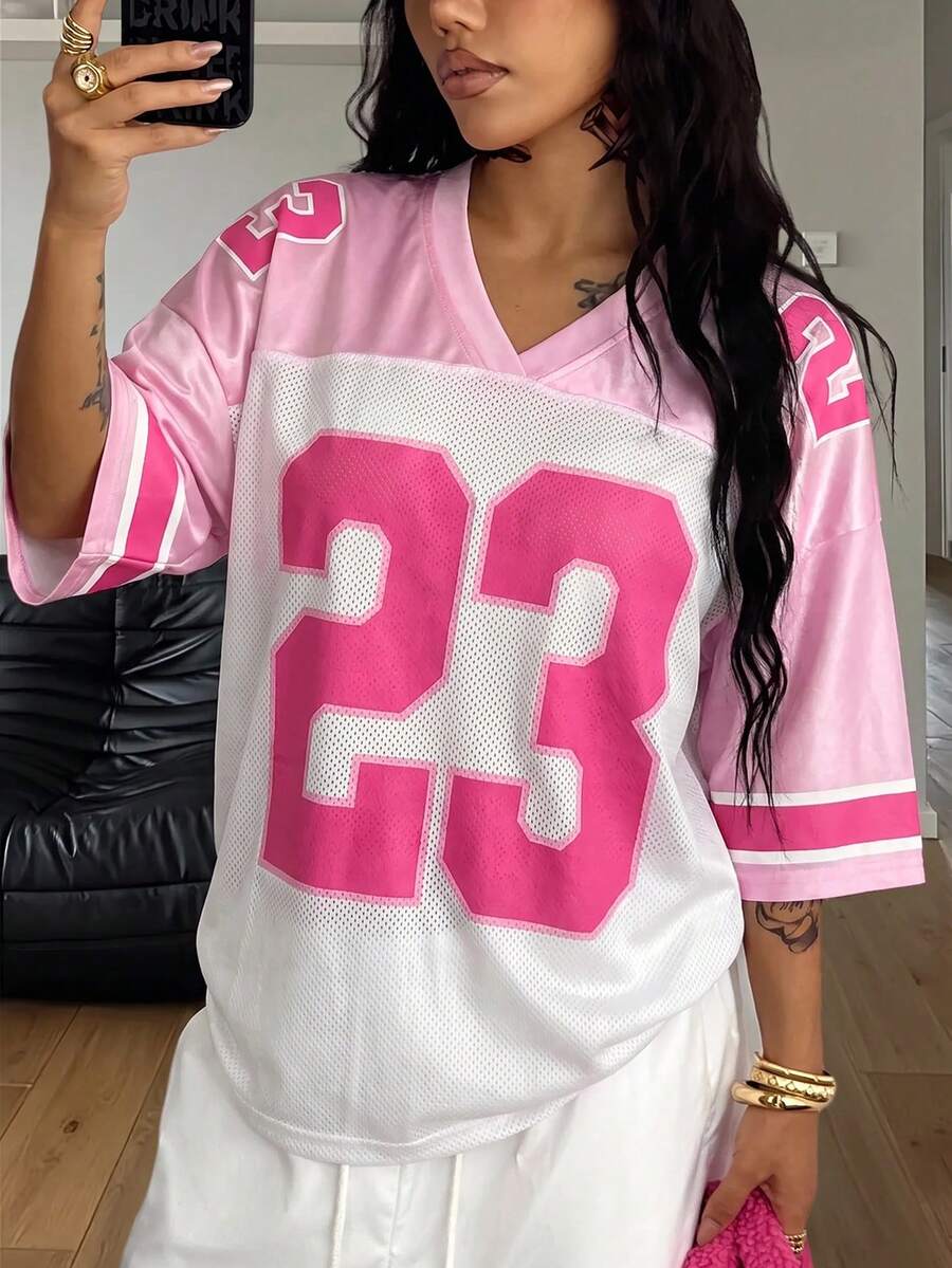 Oversized short-sleeve football jersey top featuring a V-neckline, contrast binding, and graphic number print.