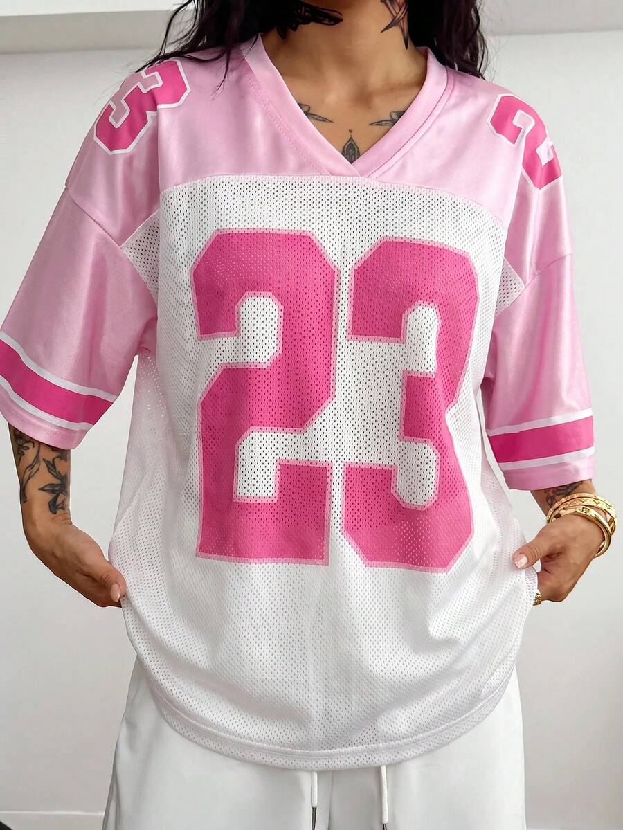 Oversized short-sleeve football jersey top featuring a V-neckline, contrast binding, and graphic number print.