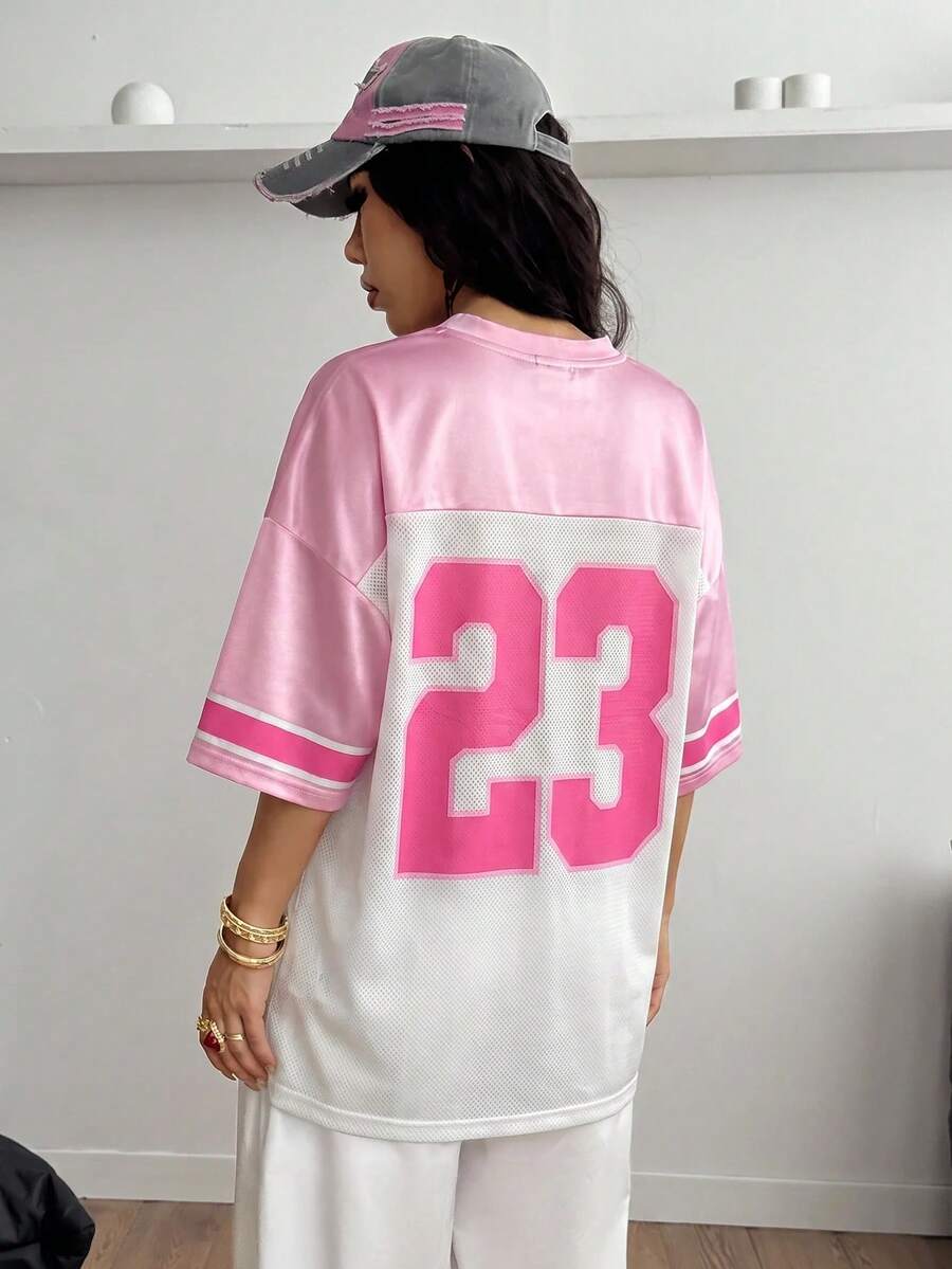 Oversized short-sleeve football jersey top featuring a V-neckline, contrast binding, and graphic number print.