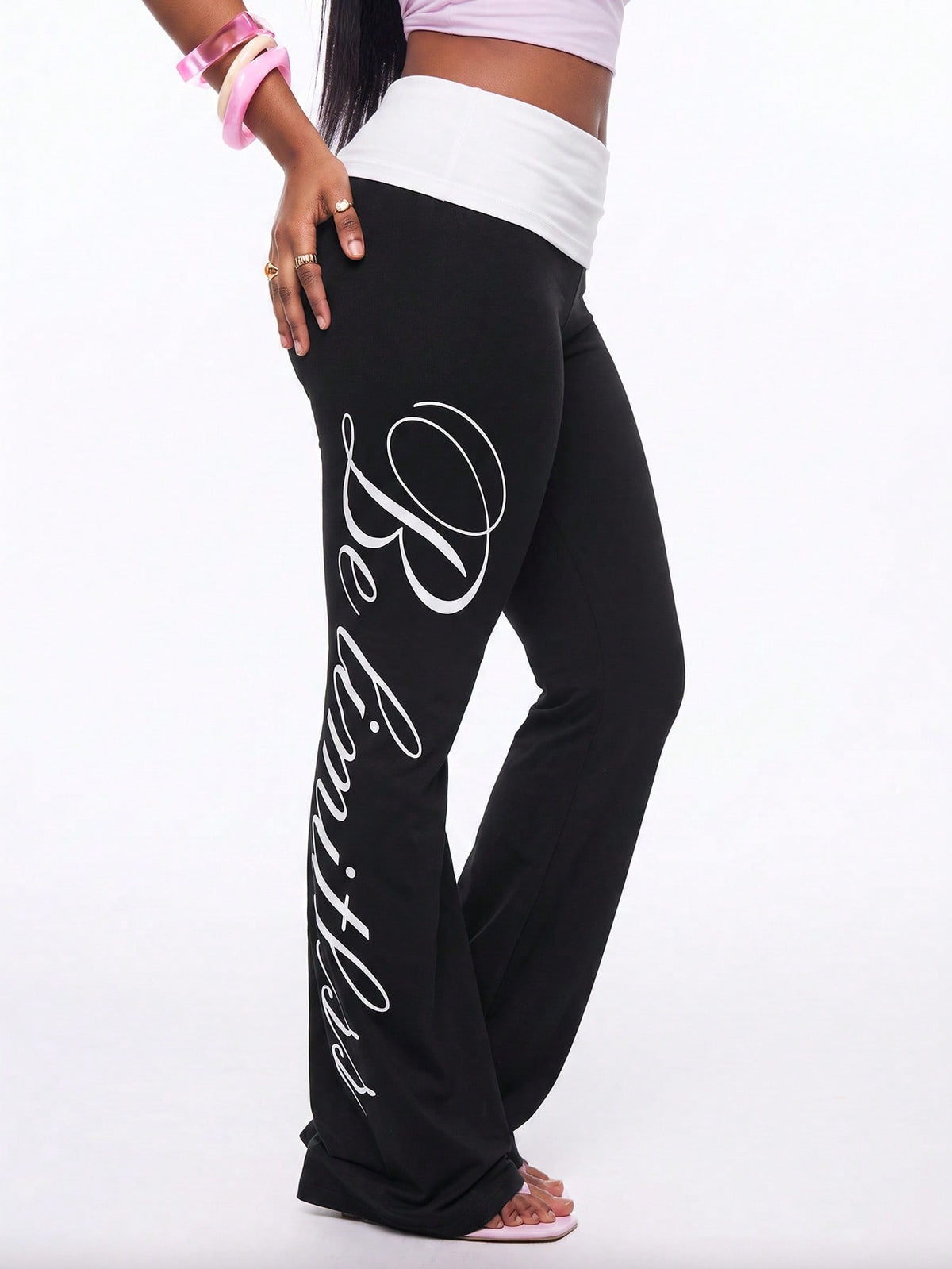 Women's black and white polka dot flare leg pants with side drawstring and ruched details