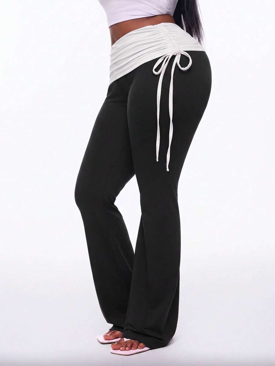 Women's black and white polka dot flare leg pants with side drawstring and ruched details