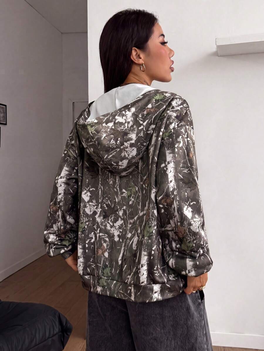 Women's army green camo zip up hoodie with drop shoulder sleeves, front pockets, and drawstring hood
