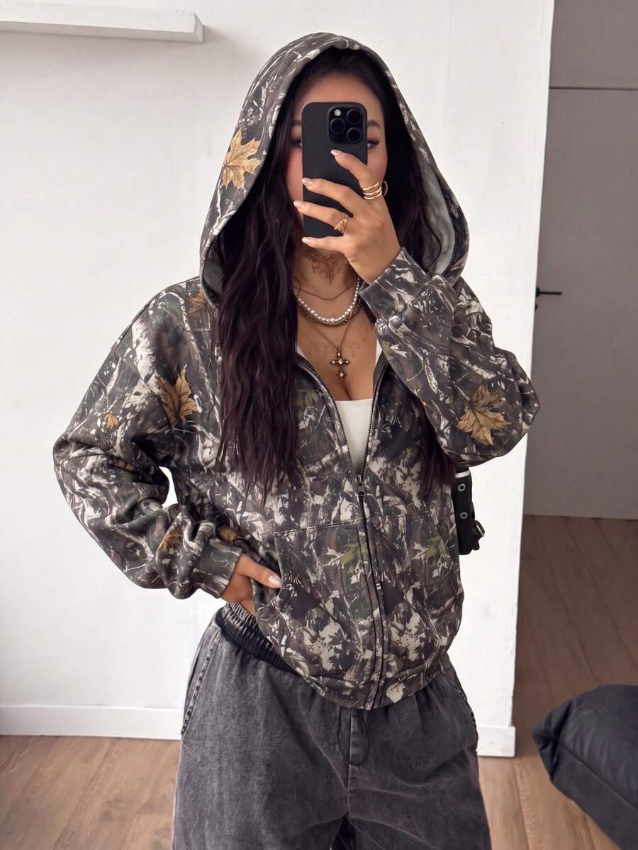Women's army green camo zip up hoodie with drop shoulder sleeves, front pockets, and drawstring hood
