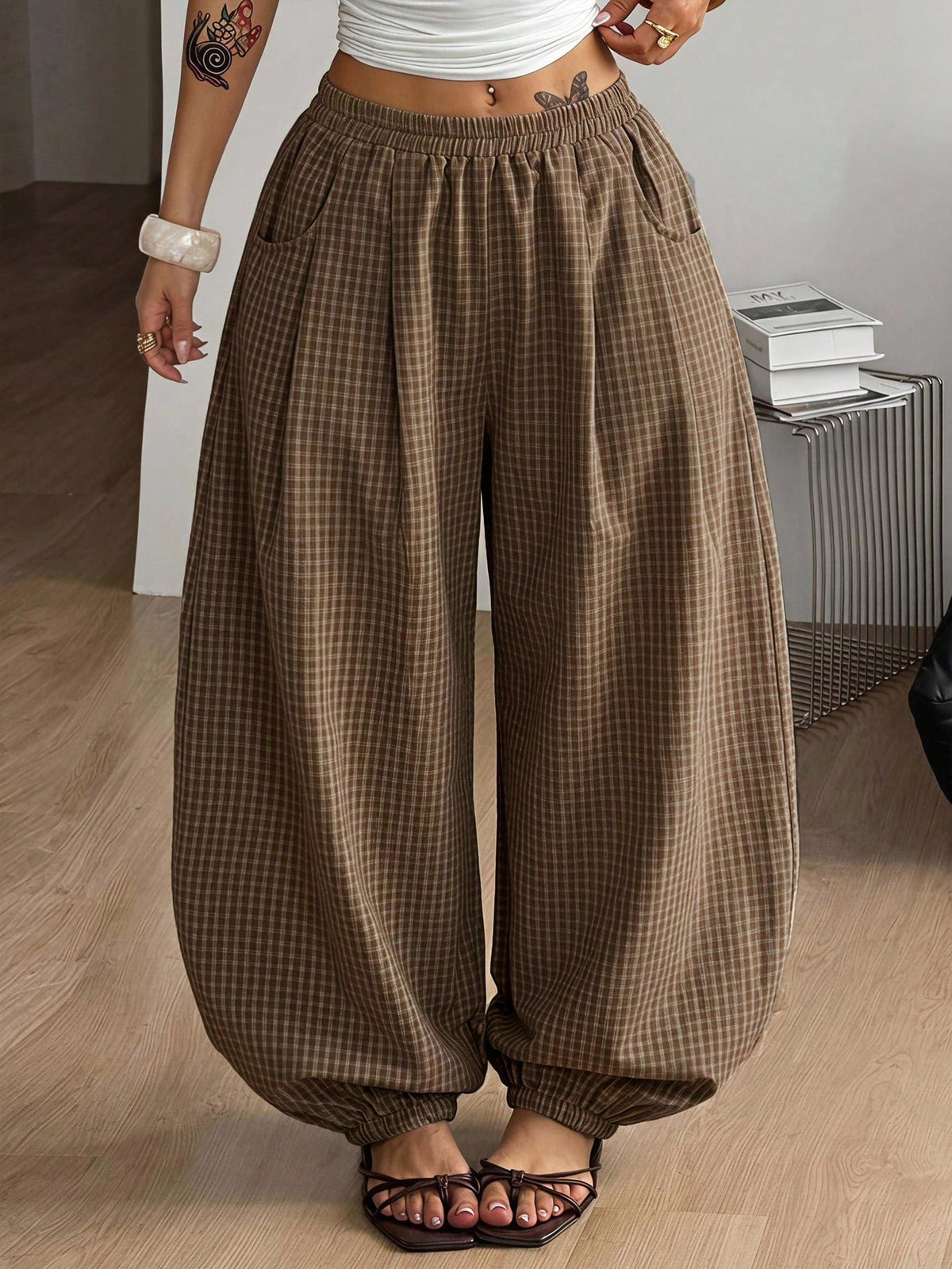 Women's loose-fit black bloomer pants made of 100% cotton featuring an elastic waistband and side pockets.