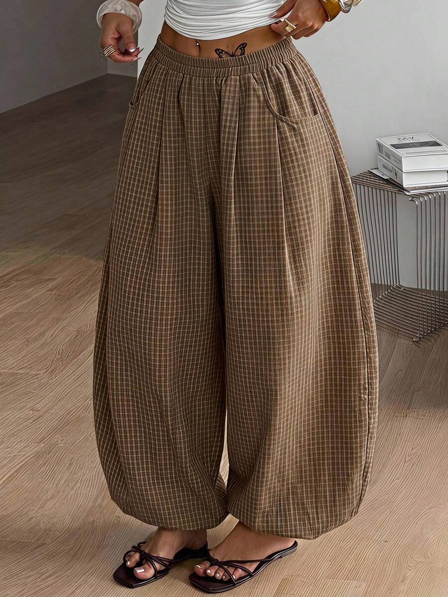 Women's loose-fit black bloomer pants made of 100% cotton featuring an elastic waistband and side pockets.