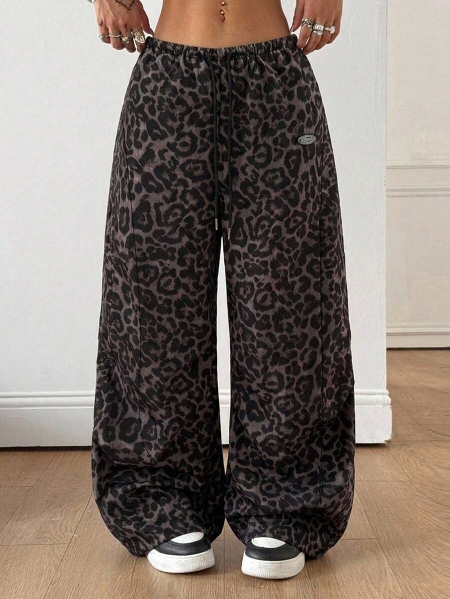 Women's black baggy jogger pants with an adjustable drawstring waist and colorblock polka dot geometric pattern.
