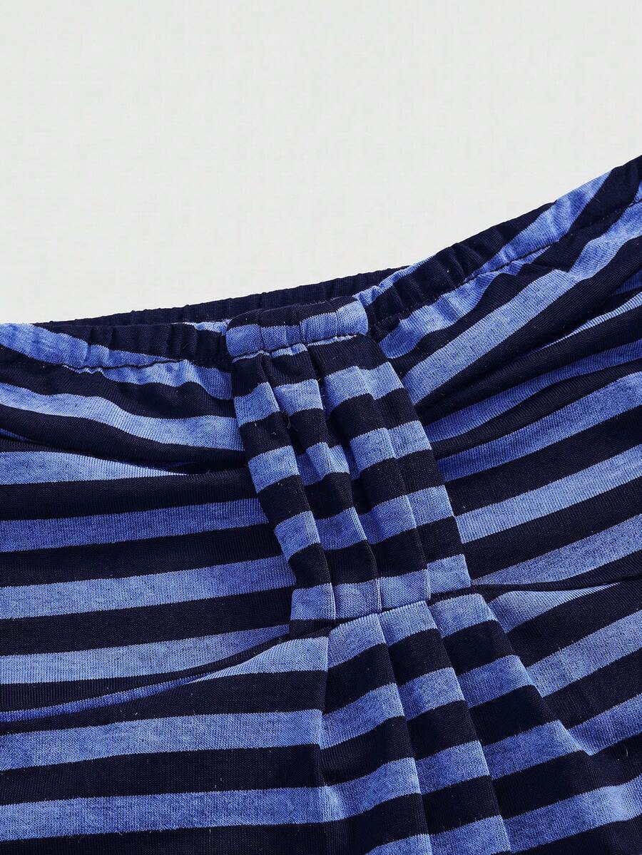 Women's striped strapless tube top featuring ruched detailing, flared hem, and stretchy knit fabric.