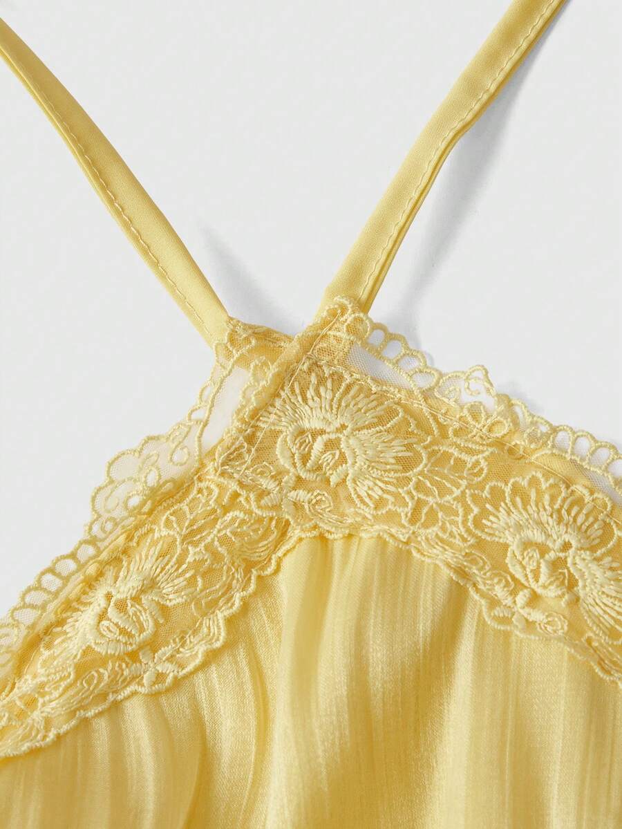 Front and back view of a women's halter neck sleeveless mini dress with contrast lace patchwork, tie knot backless detail, and layered ruffle hem.