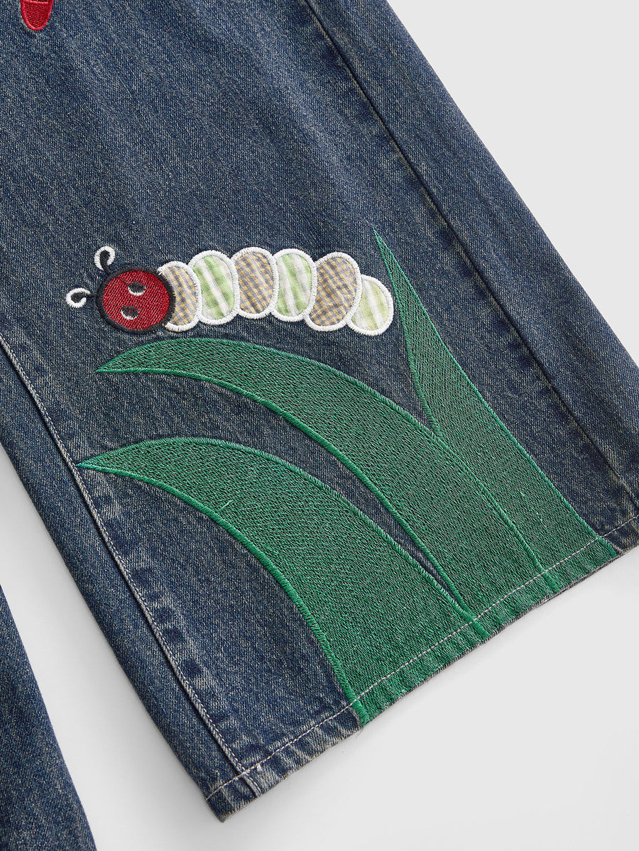 Women's loose baggy blue denim jeans featuring embroidered dragonfly and ladybug patch appliques, front pockets, and a straight-leg cut.