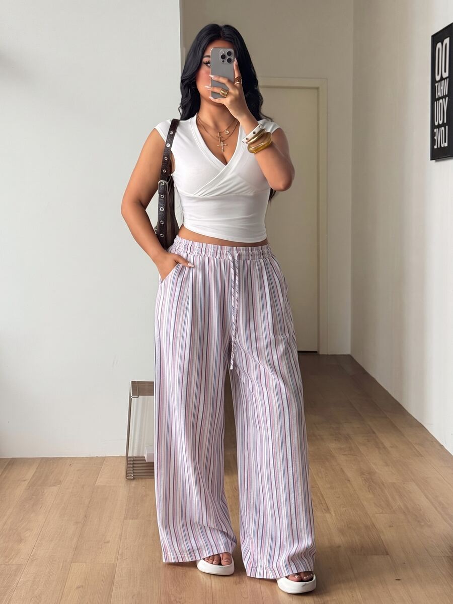 Women's loose straight leg cotton pants featuring a high waist with an adjustable drawstring knot and functional side pockets.