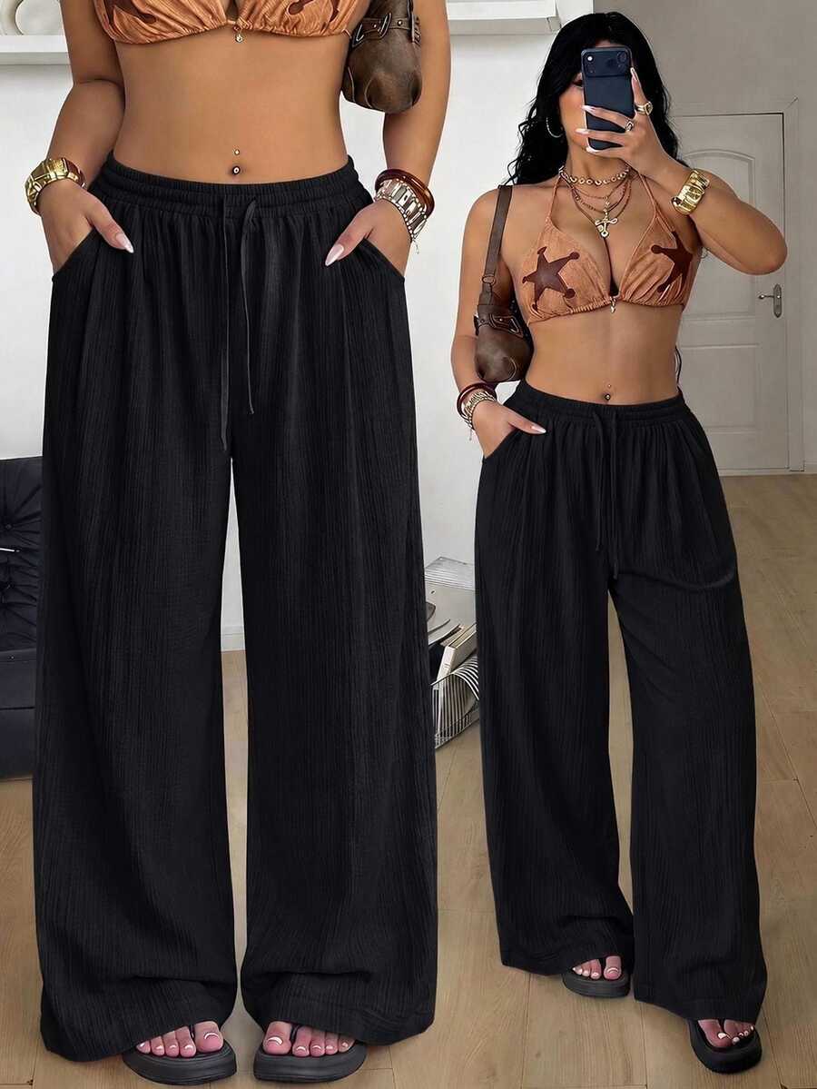 Women's loose straight leg cotton pants featuring a high waist with an adjustable drawstring knot and functional side pockets.
