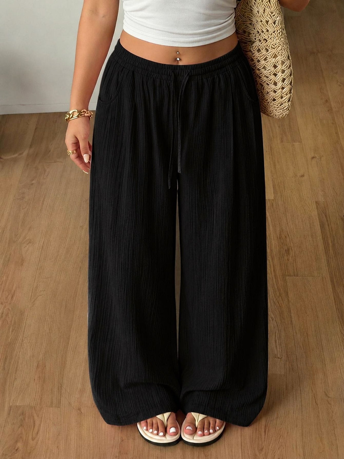 Women's loose straight leg cotton pants featuring a high waist with an adjustable drawstring knot and functional side pockets.