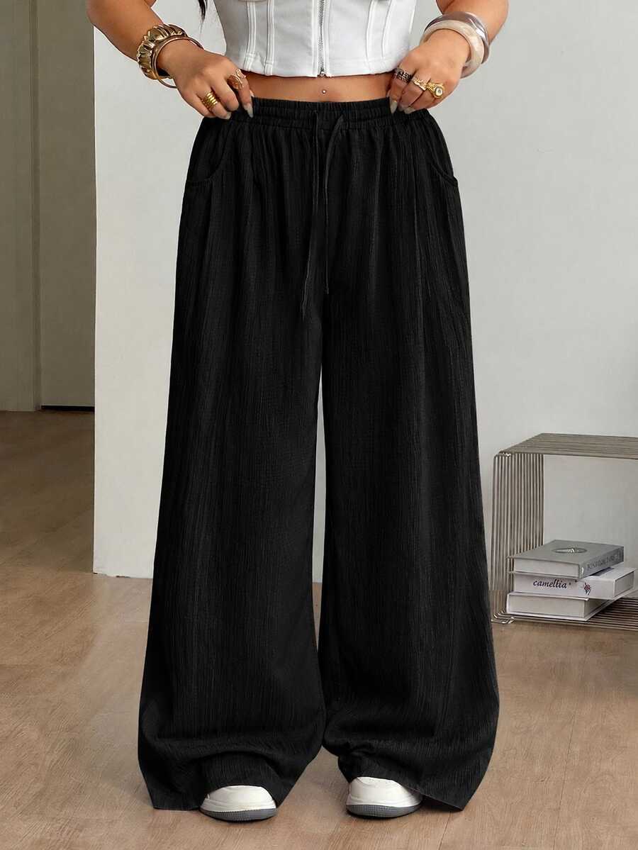 Women's loose straight leg cotton pants featuring a high waist with an adjustable drawstring knot and functional side pockets.