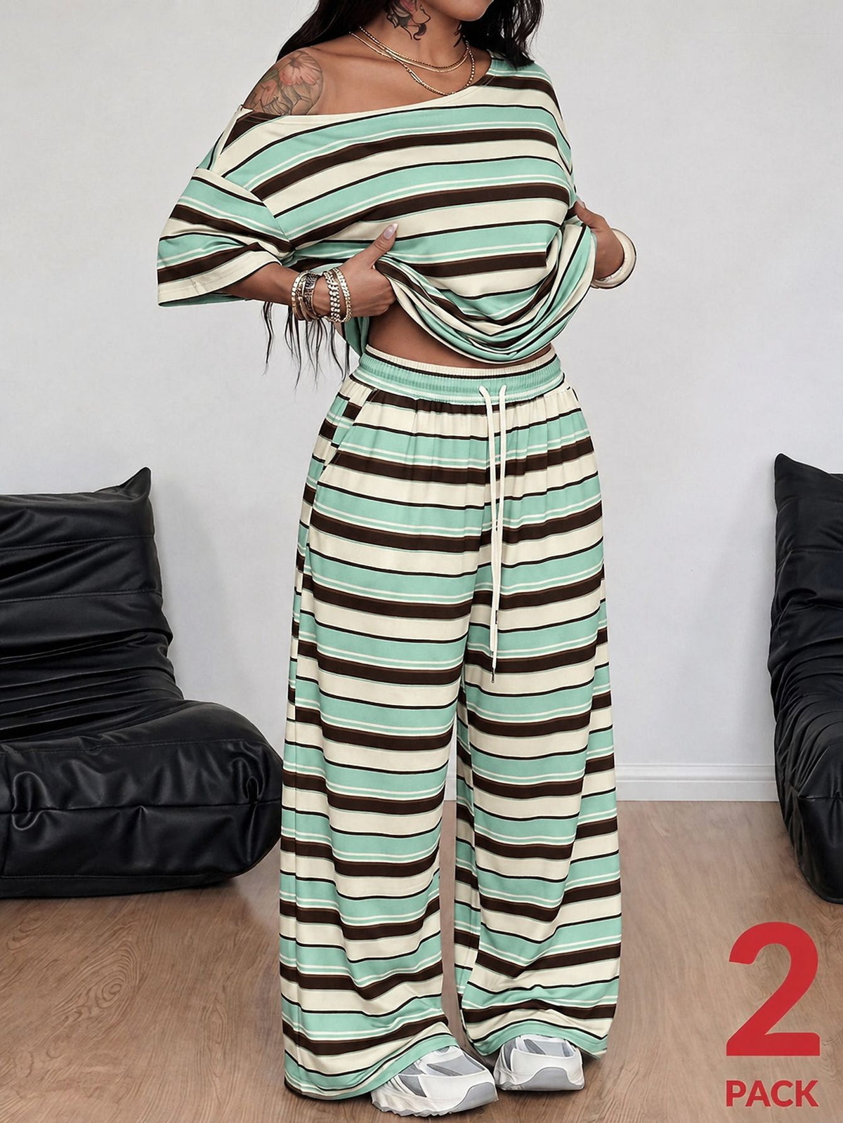 Striped two-piece casual outfit featuring an asymmetrical off-shoulder short-sleeve top and matching loose wide-leg pants with side pockets.