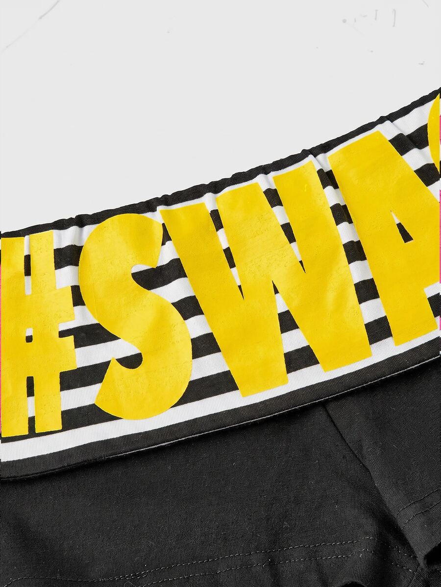 Women's ultra low waist mini shorts with folded waistband, striped letter print, and studded details in stretchy knitted fabric.
