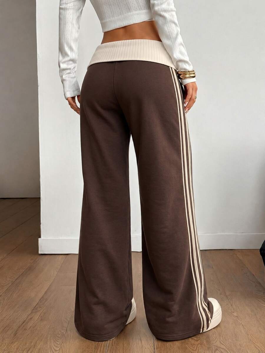 Women's wide leg flare sweatpants featuring a black and white colorblock contrast fold waistband and side stripe details.