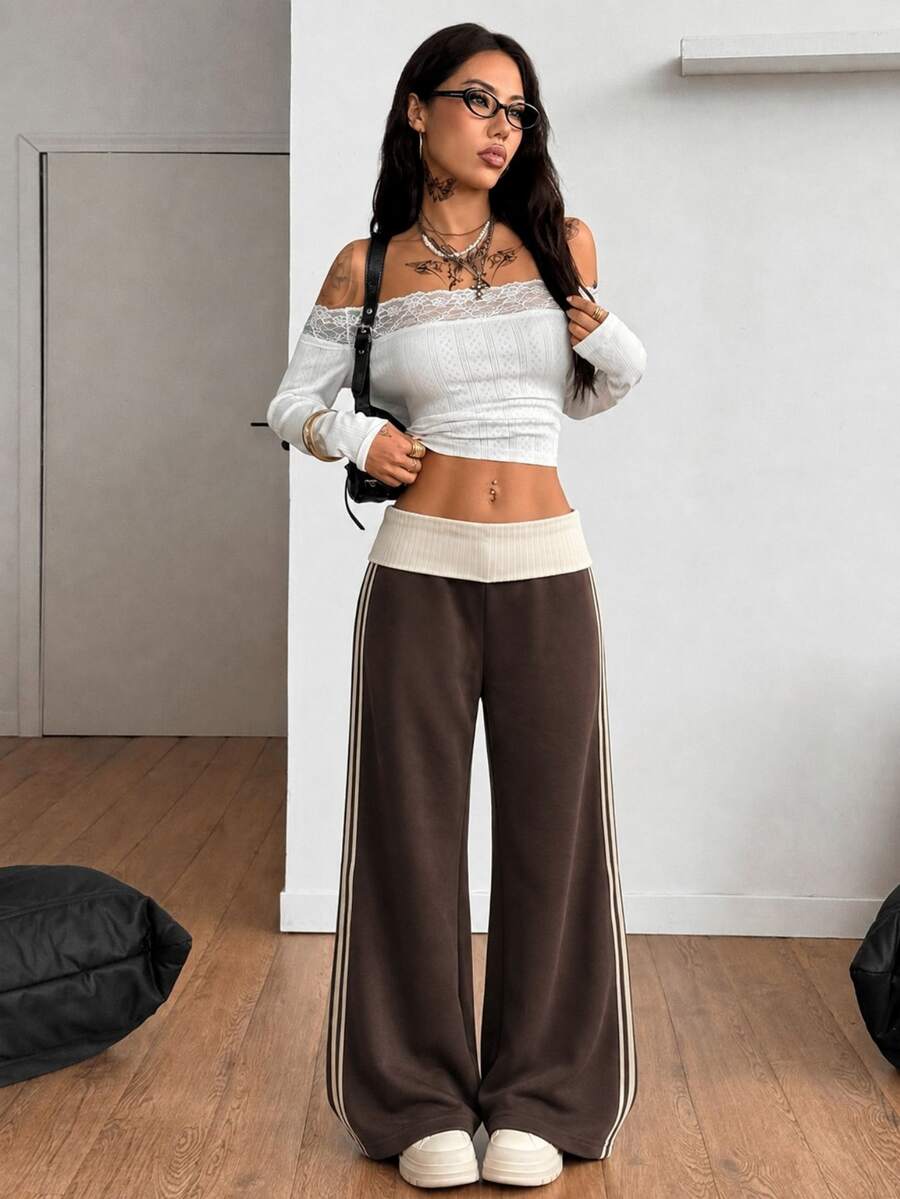 Women's wide leg flare sweatpants featuring a black and white colorblock contrast fold waistband and side stripe details.