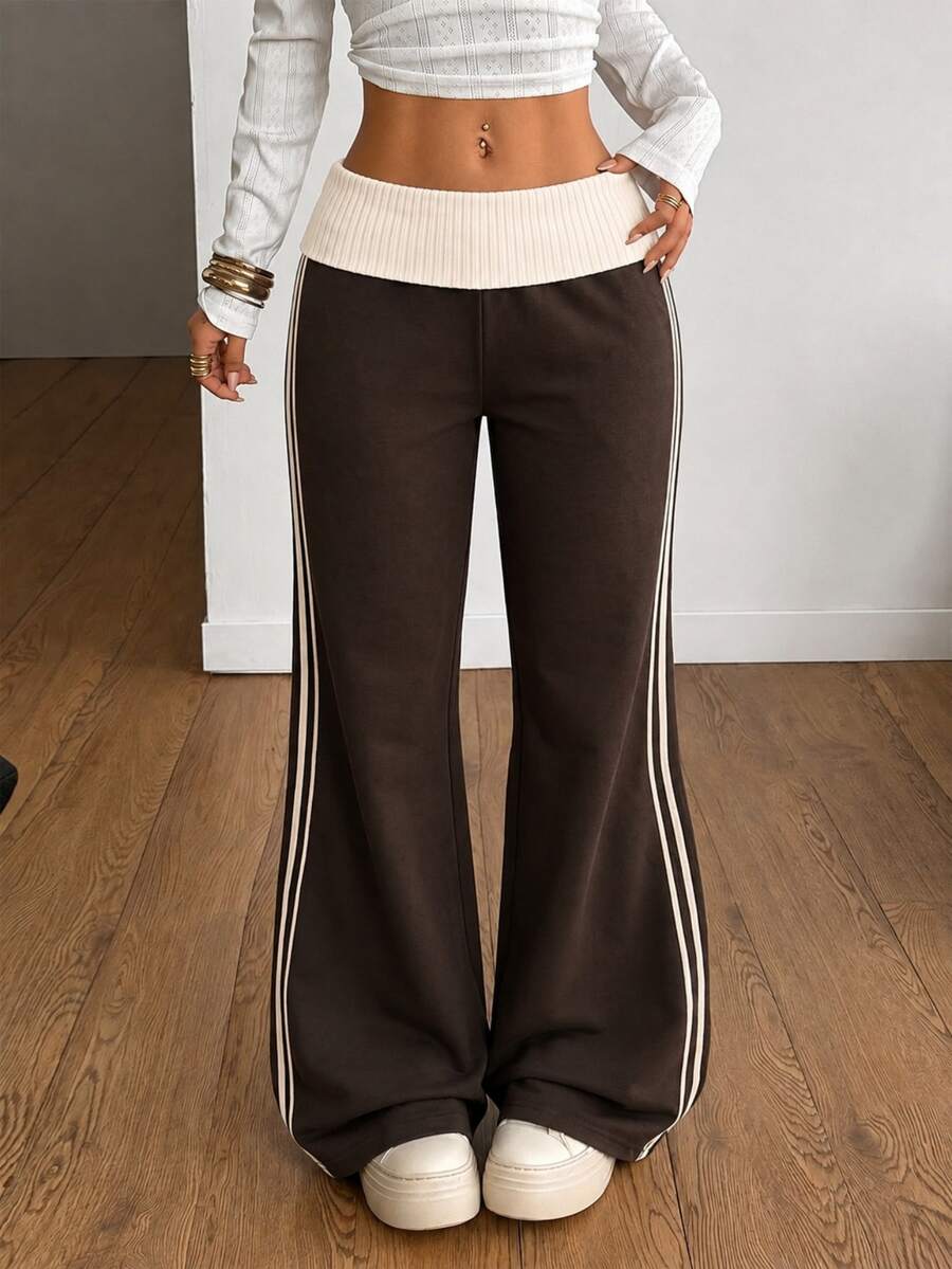 Women's wide leg flare sweatpants featuring a black and white colorblock contrast fold waistband and side stripe details.