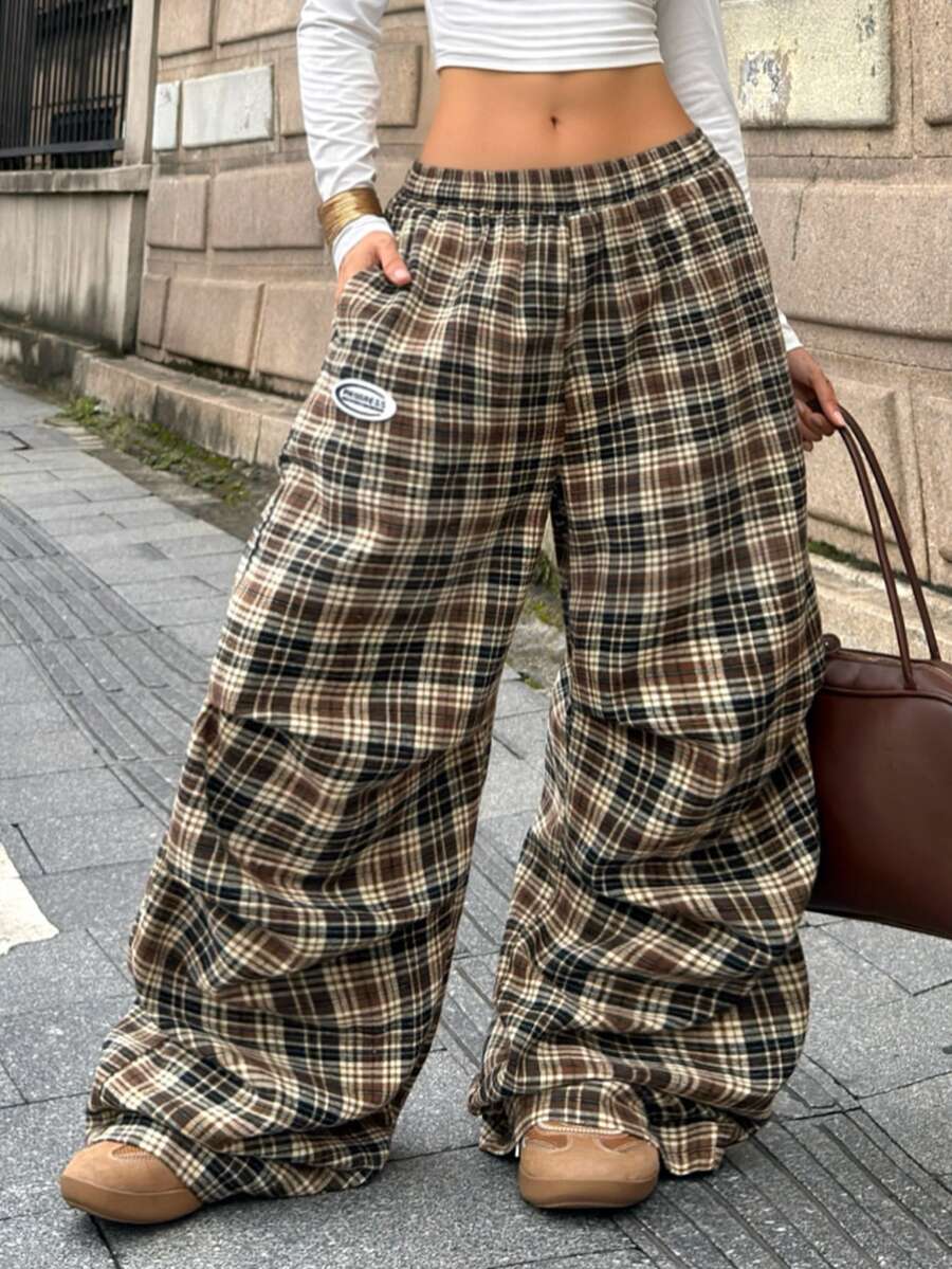 Women's black and white striped wide leg pants featuring an elastic drawstring waistband, side pockets, and a loose straight leg fit.
