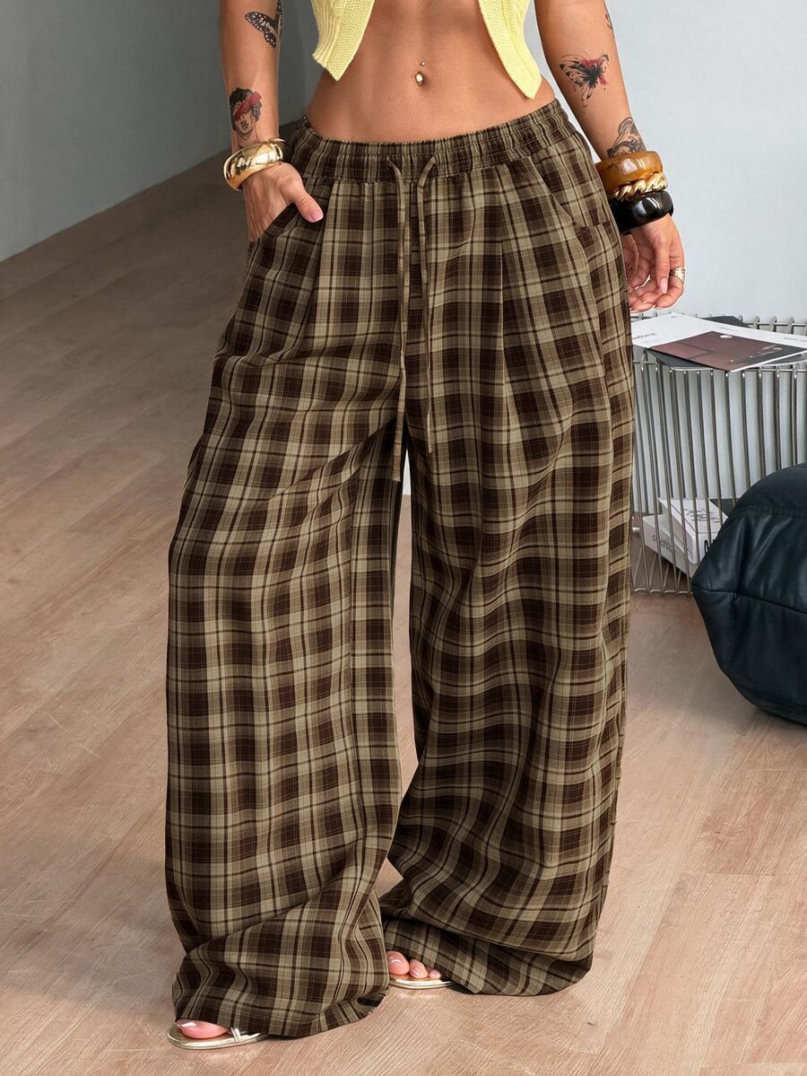 Women's loose fit brown and tan plaid wide leg pants featuring an elastic drawstring waist and side pockets.