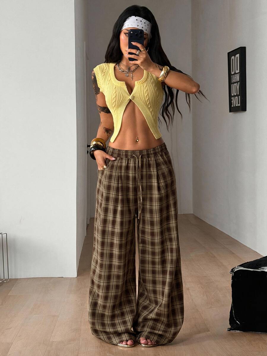 Women's loose fit brown and tan plaid wide leg pants featuring an elastic drawstring waist and side pockets.