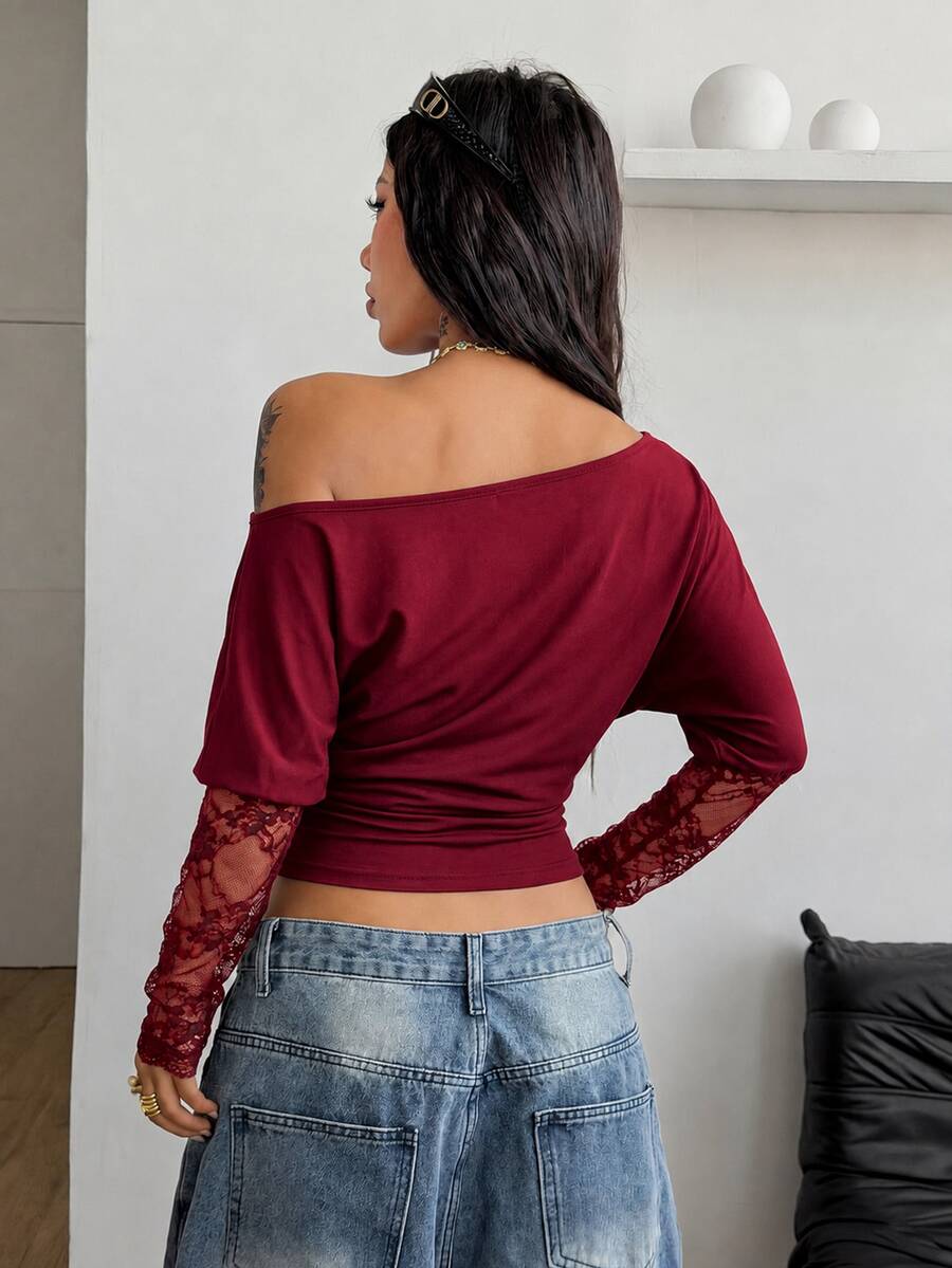 Women's black long sleeve t-shirt featuring delicate contrast lace details and a boat neckline in a knitted stretch fabric.