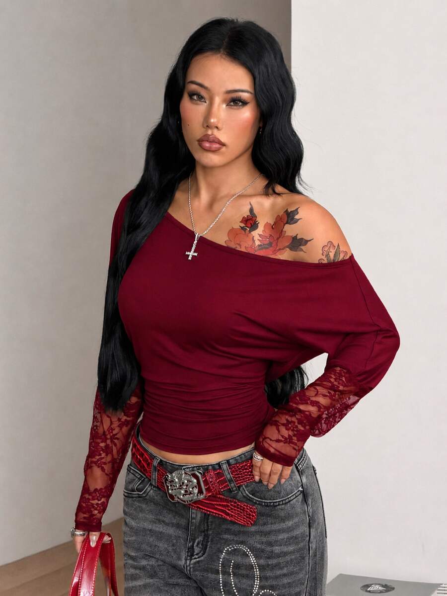 Women's black long sleeve t-shirt featuring delicate contrast lace details and a boat neckline in a knitted stretch fabric.