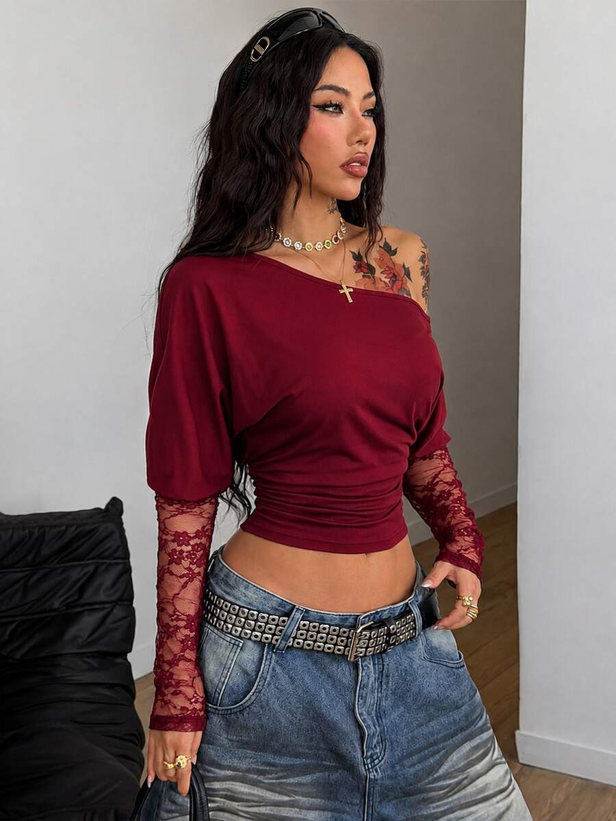 Women's black long sleeve t-shirt featuring delicate contrast lace details and a boat neckline in a knitted stretch fabric.