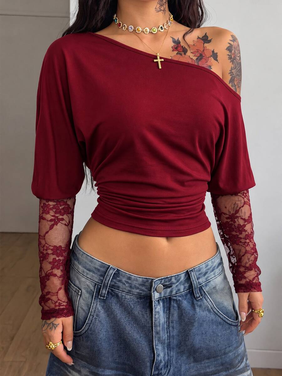 Women's black long sleeve t-shirt featuring delicate contrast lace details and a boat neckline in a knitted stretch fabric.