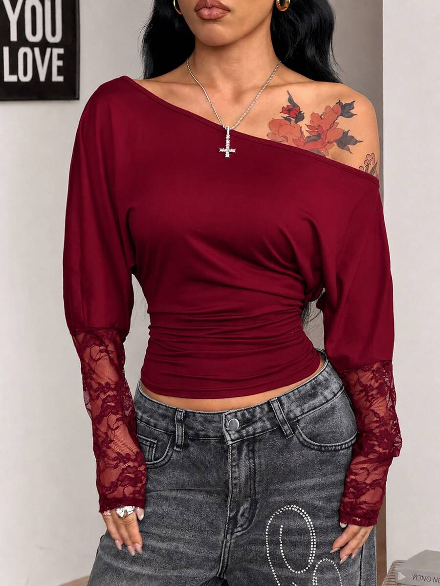 Women's black long sleeve t-shirt featuring delicate contrast lace details and a boat neckline in a knitted stretch fabric.