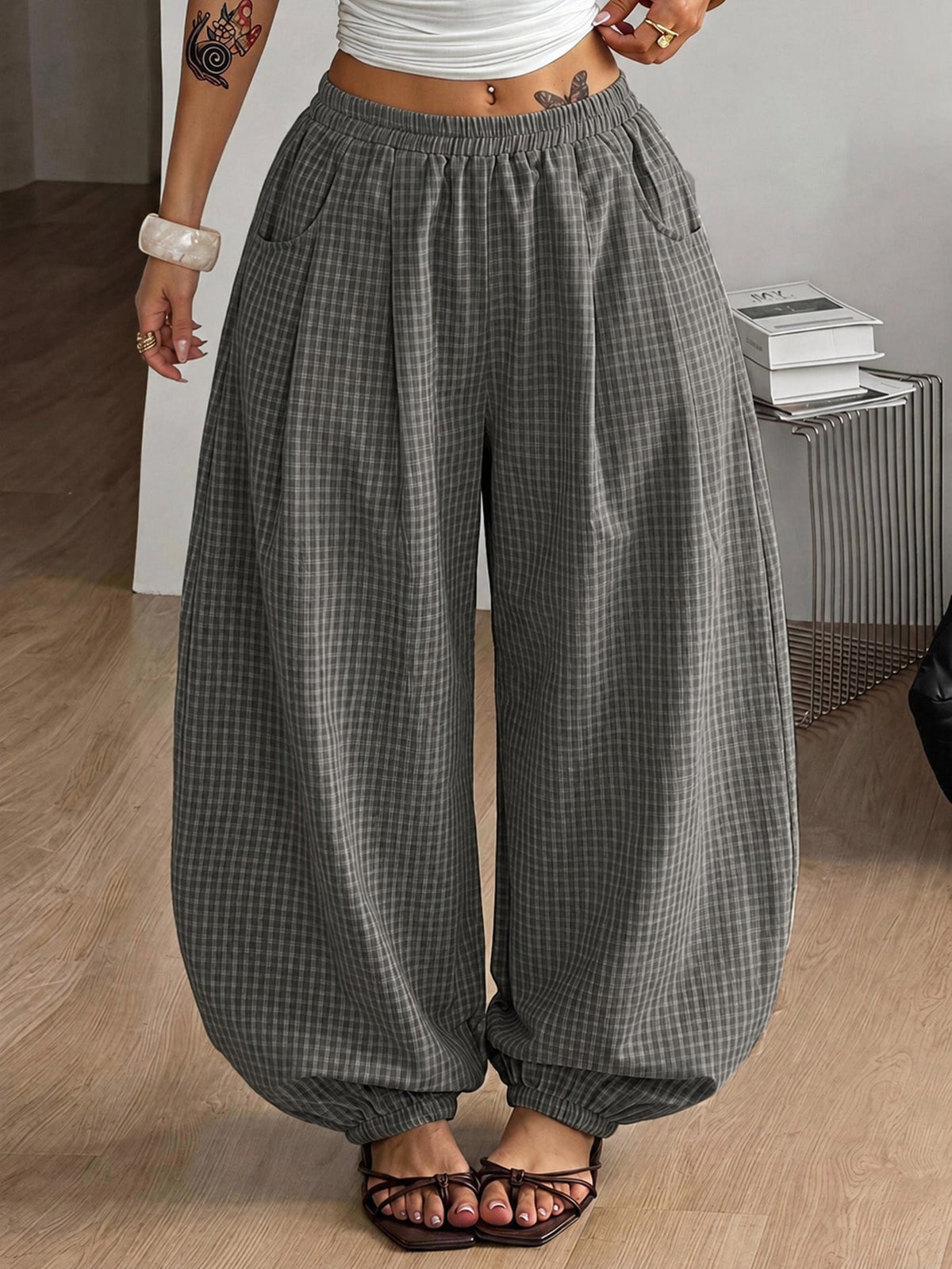 Women's loose-fit black bloomer pants made of 100% cotton featuring an elastic waistband and side pockets.