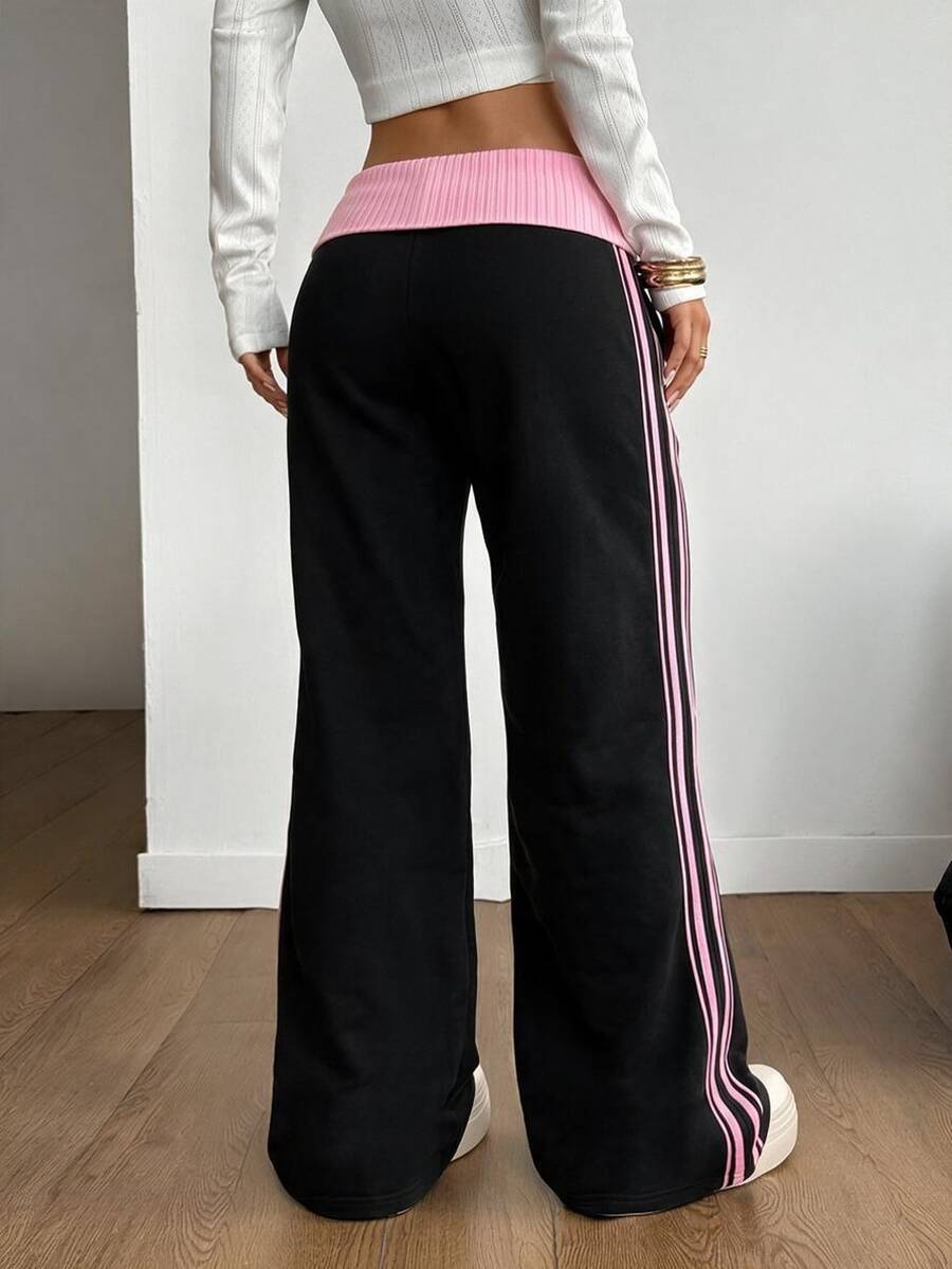 Women's wide leg flare sweatpants featuring a black and white colorblock contrast fold waistband and side stripe details.
