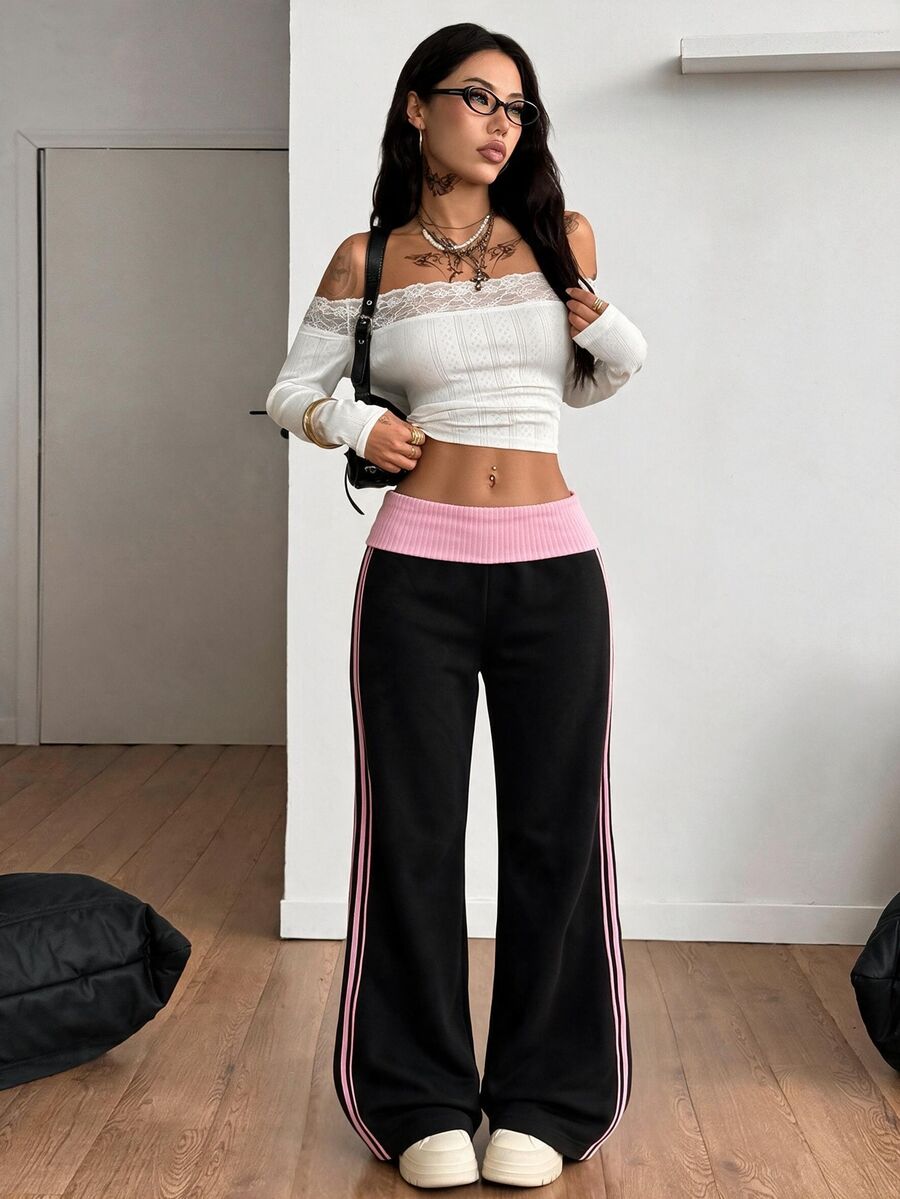 Women's wide leg flare sweatpants featuring a black and white colorblock contrast fold waistband and side stripe details.