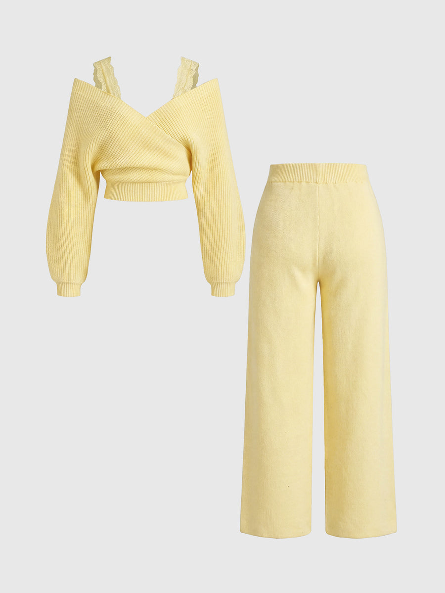 Women's two-piece rib-knit sweater set featuring a long-sleeve cold-shoulder crop top with strap details and matching wide-leg pants.
