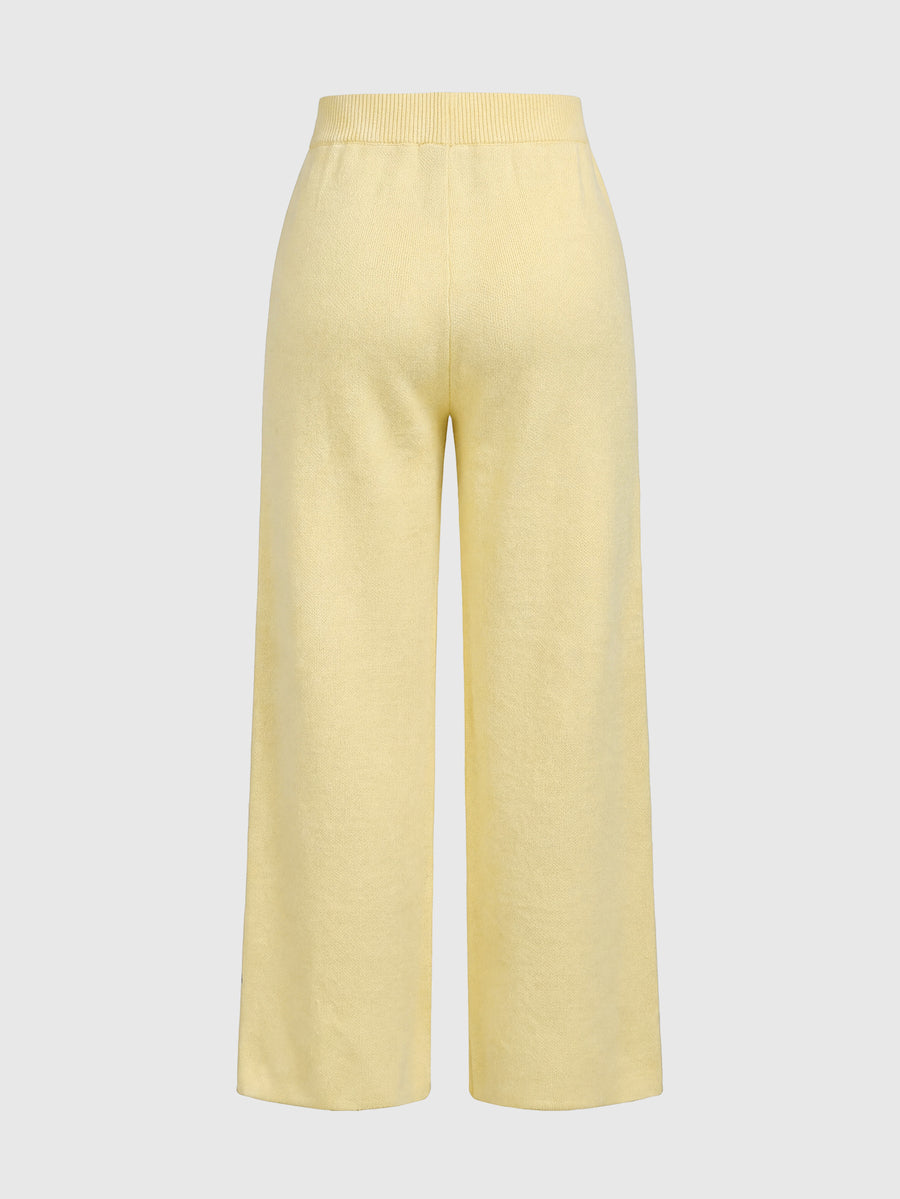 Women's two-piece rib-knit sweater set featuring a long-sleeve cold-shoulder crop top with strap details and matching wide-leg pants.