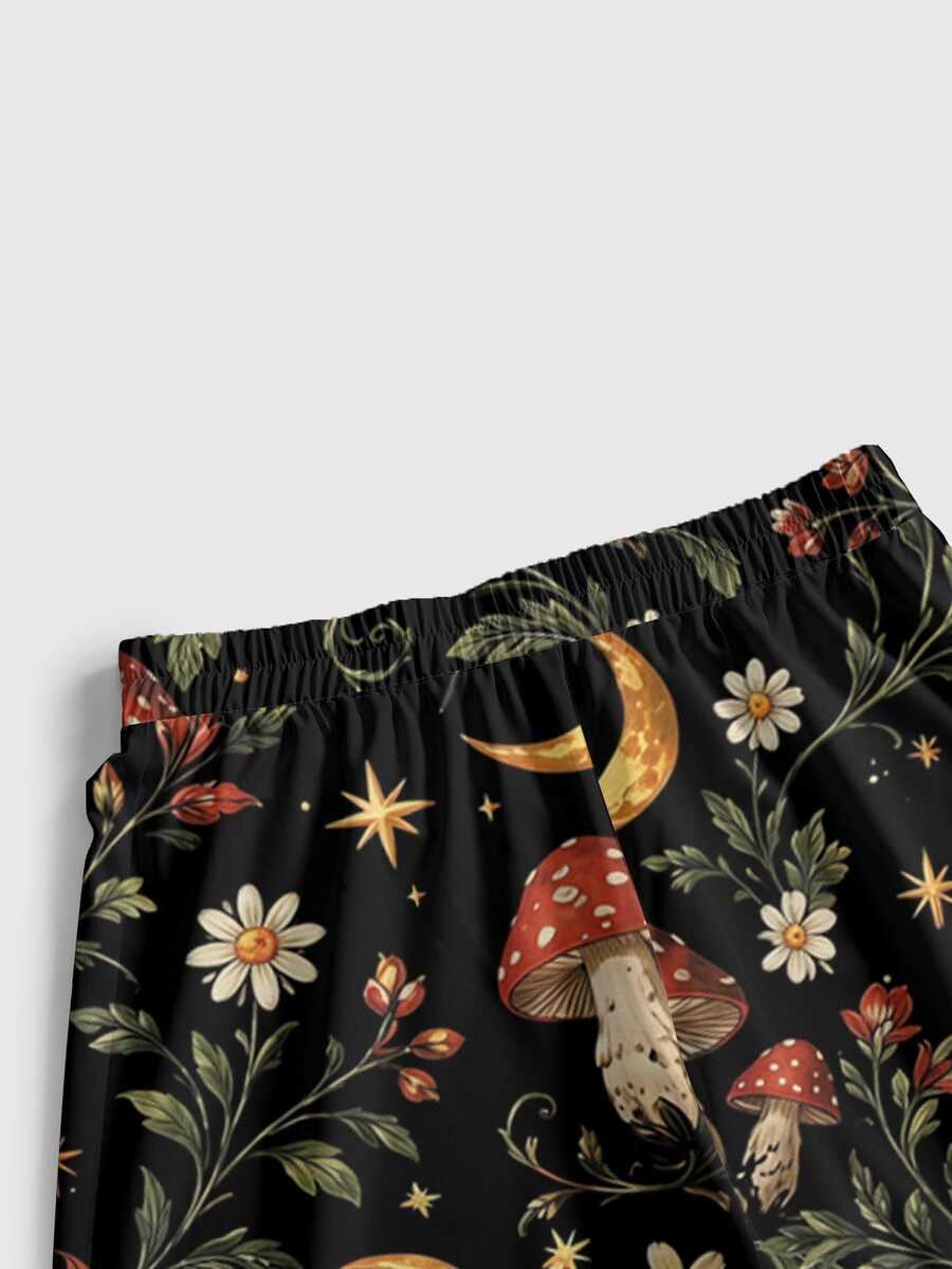 Women's plus size black gothic wide leg pants with split thigh detail and celestial moth, sun, and star pattern.