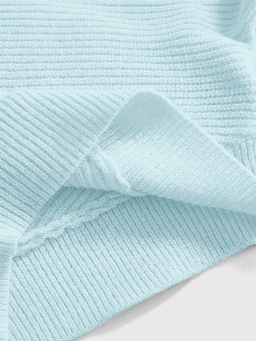Women's two-piece rib-knit sweater set featuring a long-sleeve cold-shoulder crop top with strap details and matching wide-leg pants.