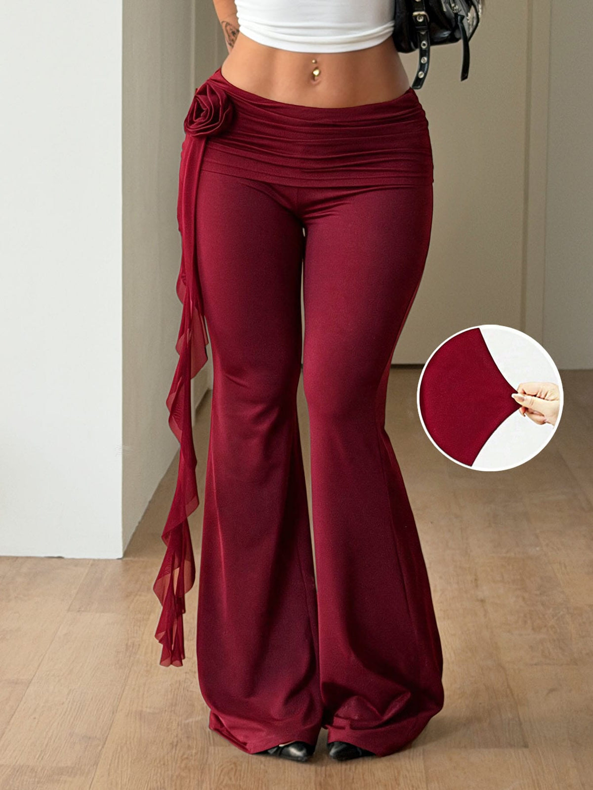 Black low waist flare pants featuring 3D rose and side stripe detailing in stretchy mesh fabric.