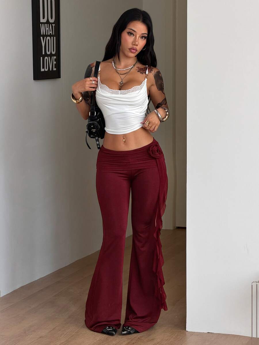 Black low waist flare pants featuring 3D rose and side stripe detailing in stretchy mesh fabric.