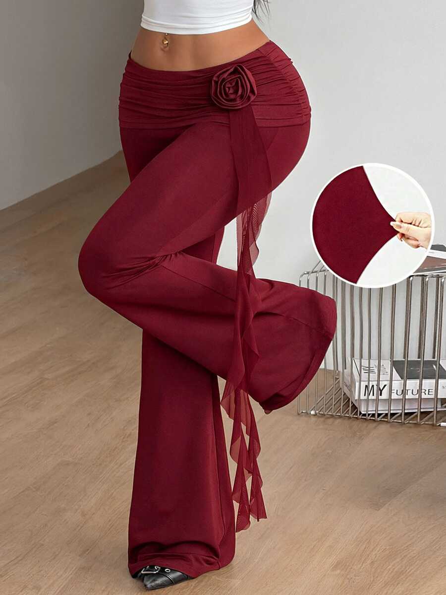Black low waist flare pants featuring 3D rose and side stripe detailing in stretchy mesh fabric.