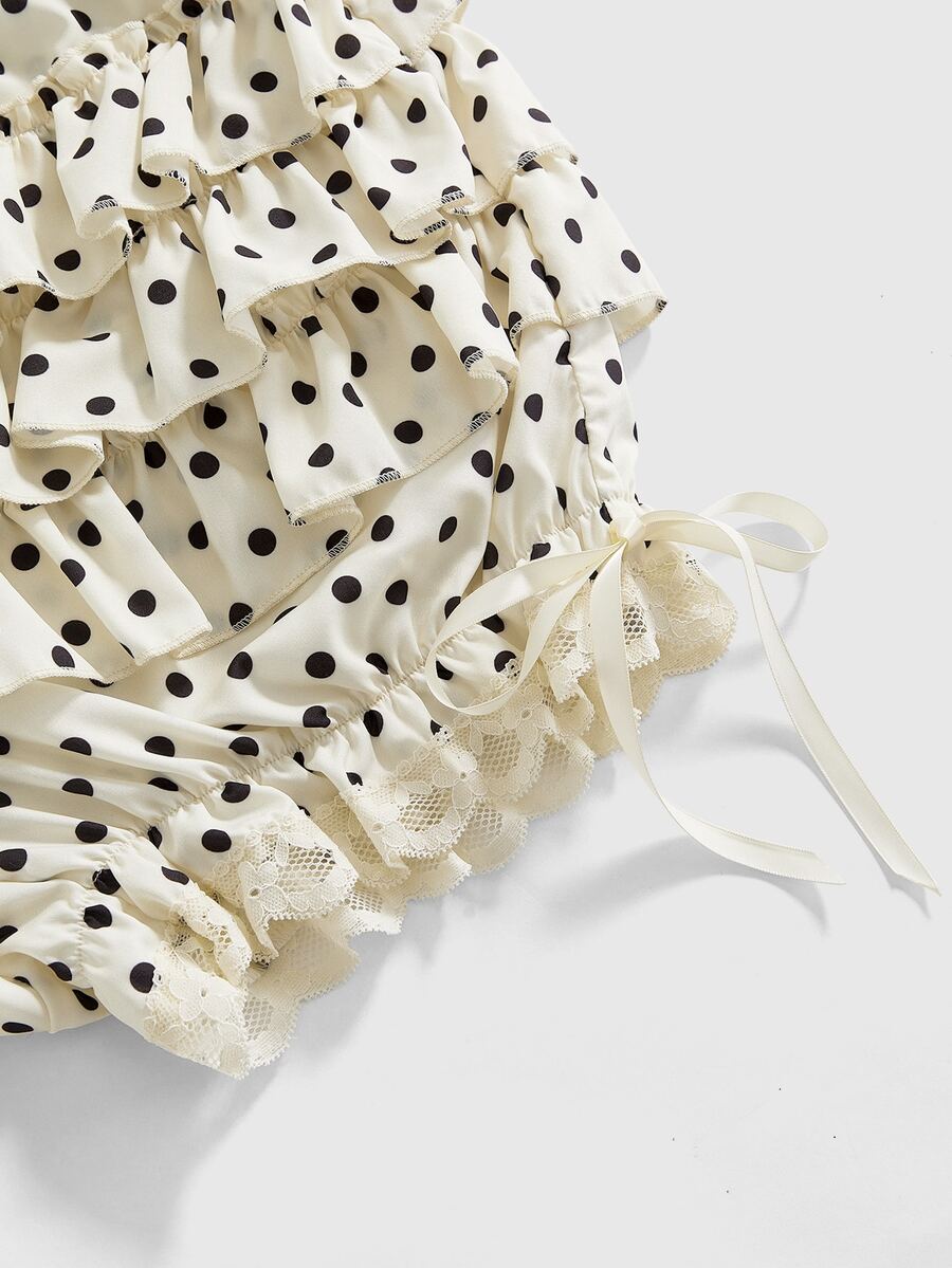 Women's tiered ruffle skort shorts featuring an elastic mid waist with front tie knot detail in woven fabric.