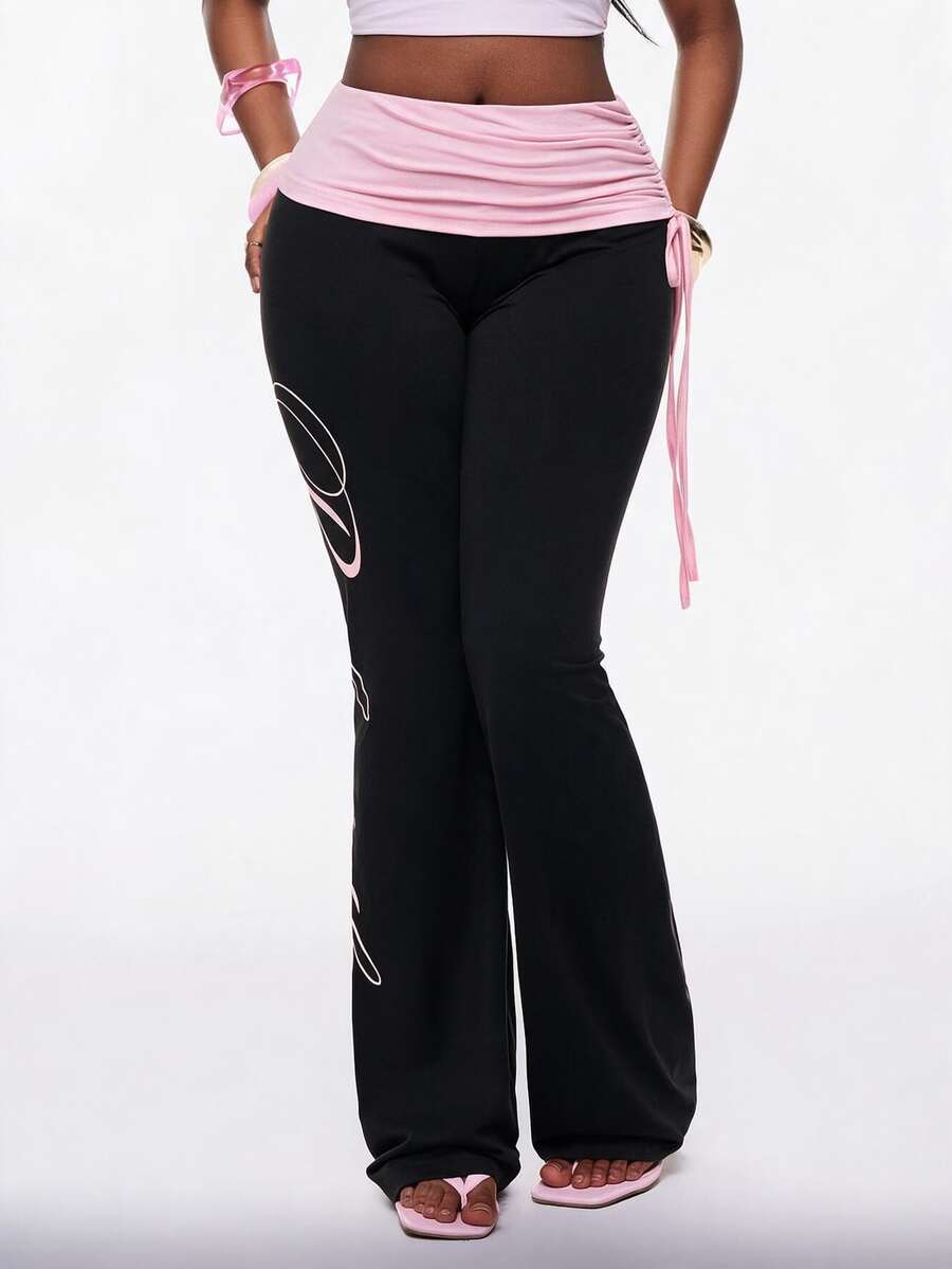 Women's black and white polka dot flare leg pants with side drawstring and ruched details