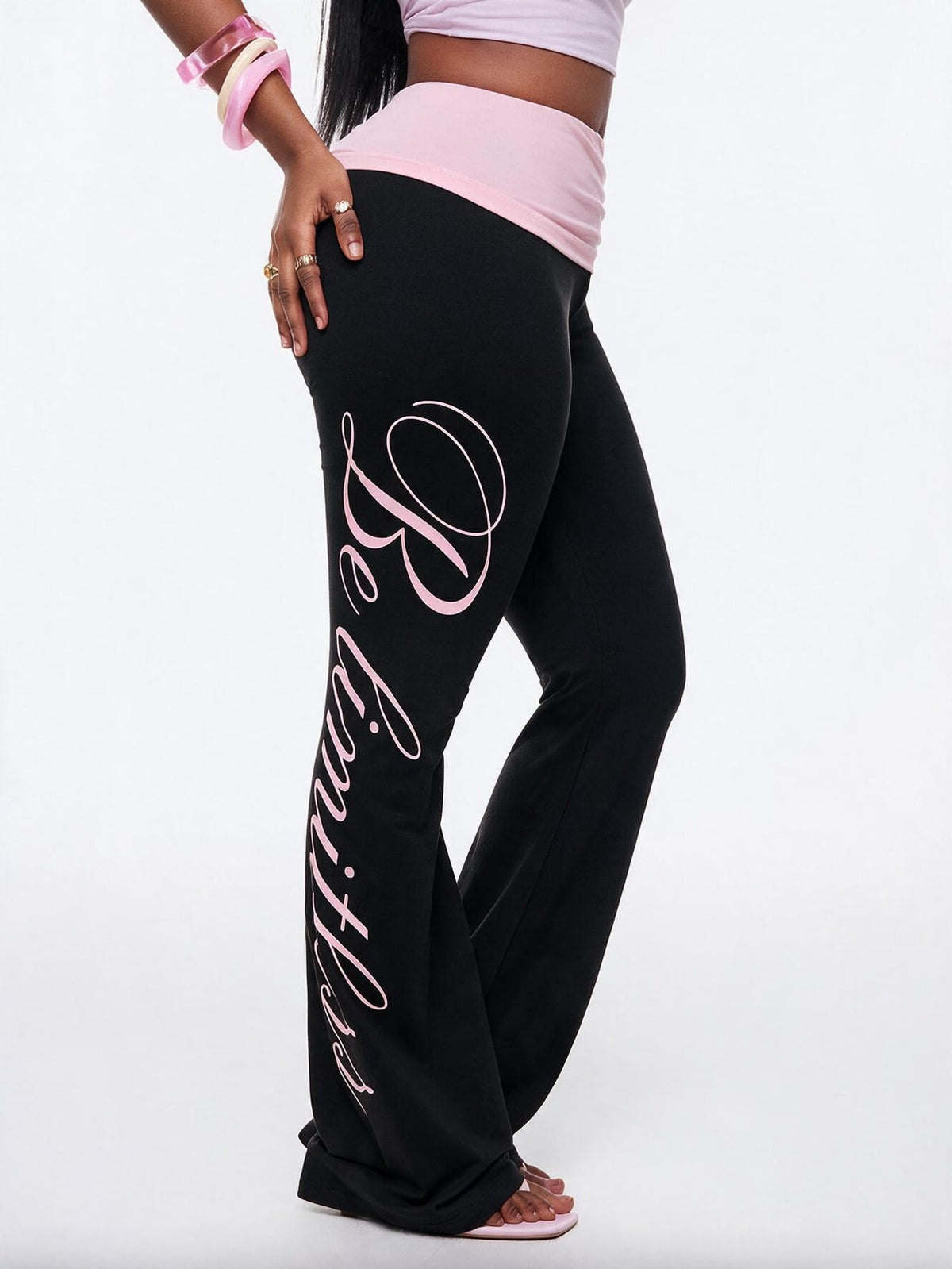Women's black and white polka dot flare leg pants with side drawstring and ruched details