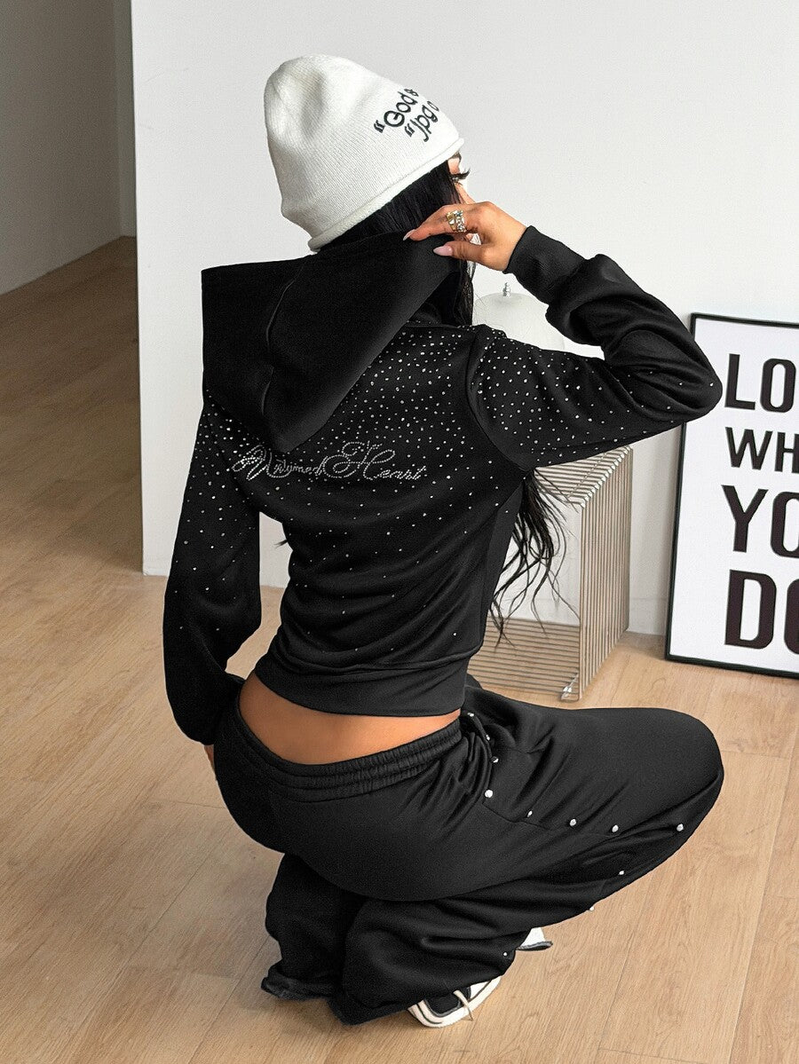 Women's black zip up hoodie featuring long flounce sleeves, a drawstring hood, and front zip closure in a knitted fabric.