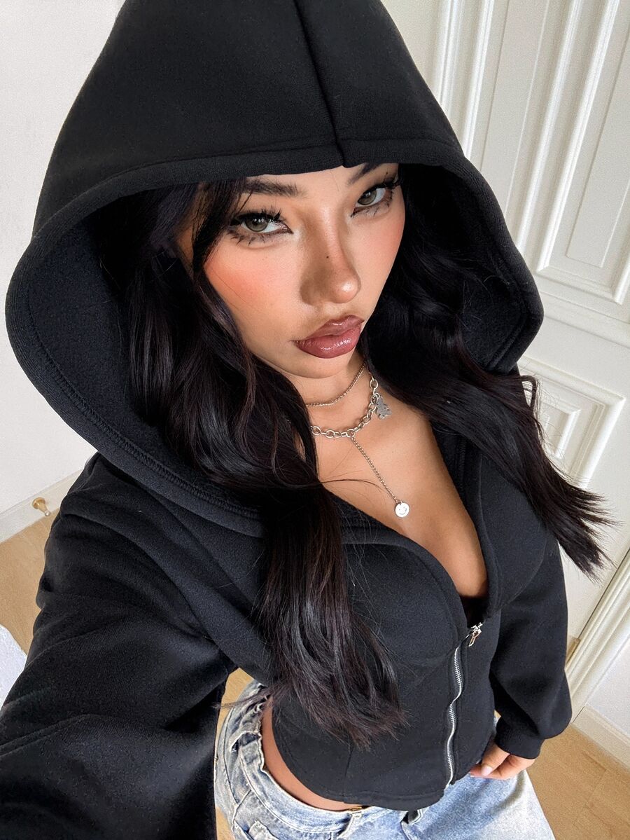 Women's black oversized zip-up hooded sweatshirt with drawstring hood and long sleeves.