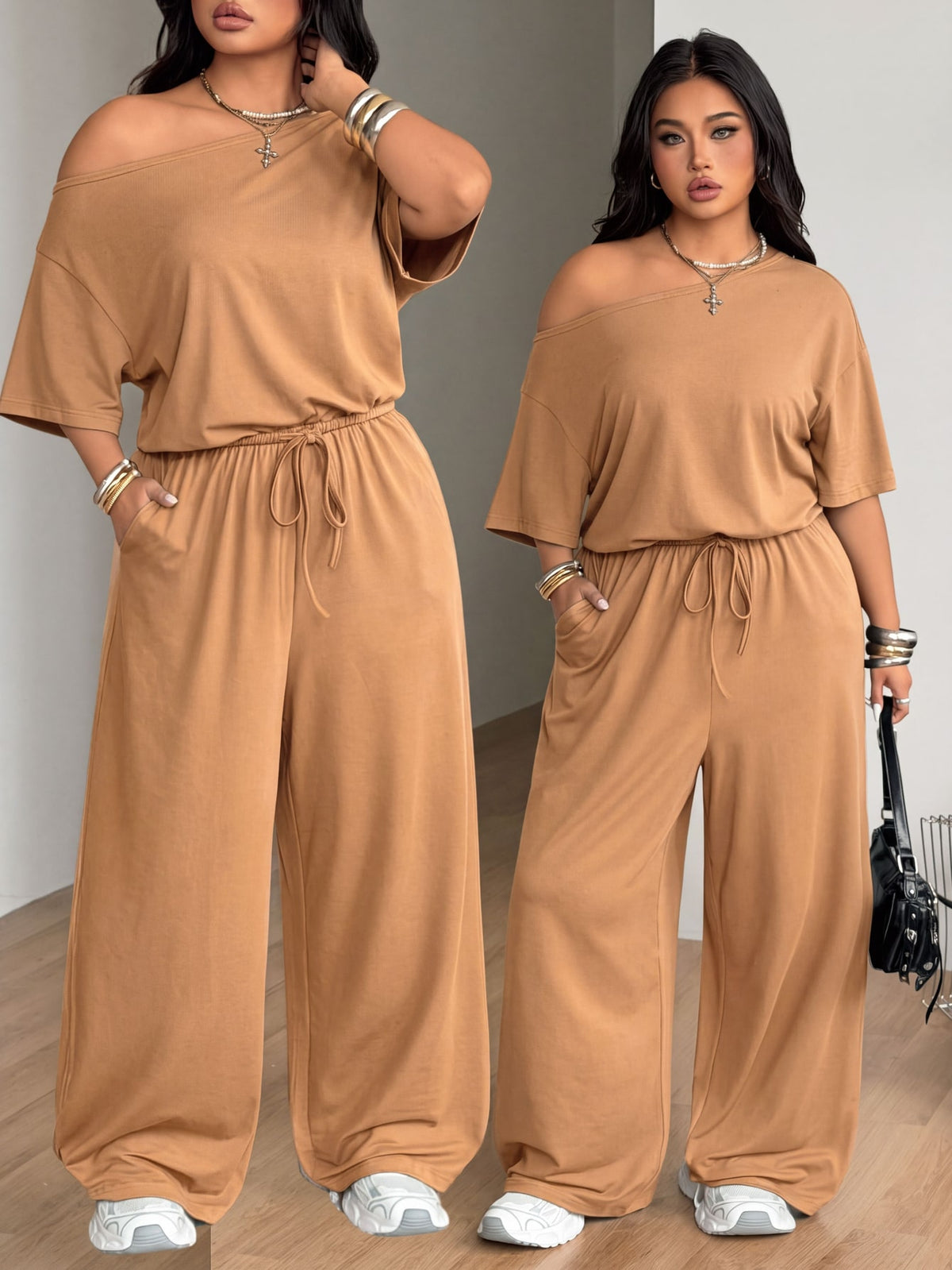 Plus size women's wide leg jumpsuit in dark grey featuring an asymmetrical neckline, short batwing sleeves, and a drawstring high waist with side pockets.