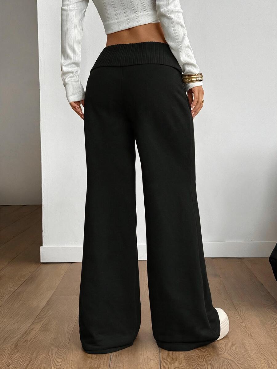 Women's wide leg flare sweatpants featuring a black and white colorblock contrast fold waistband and side stripe details.