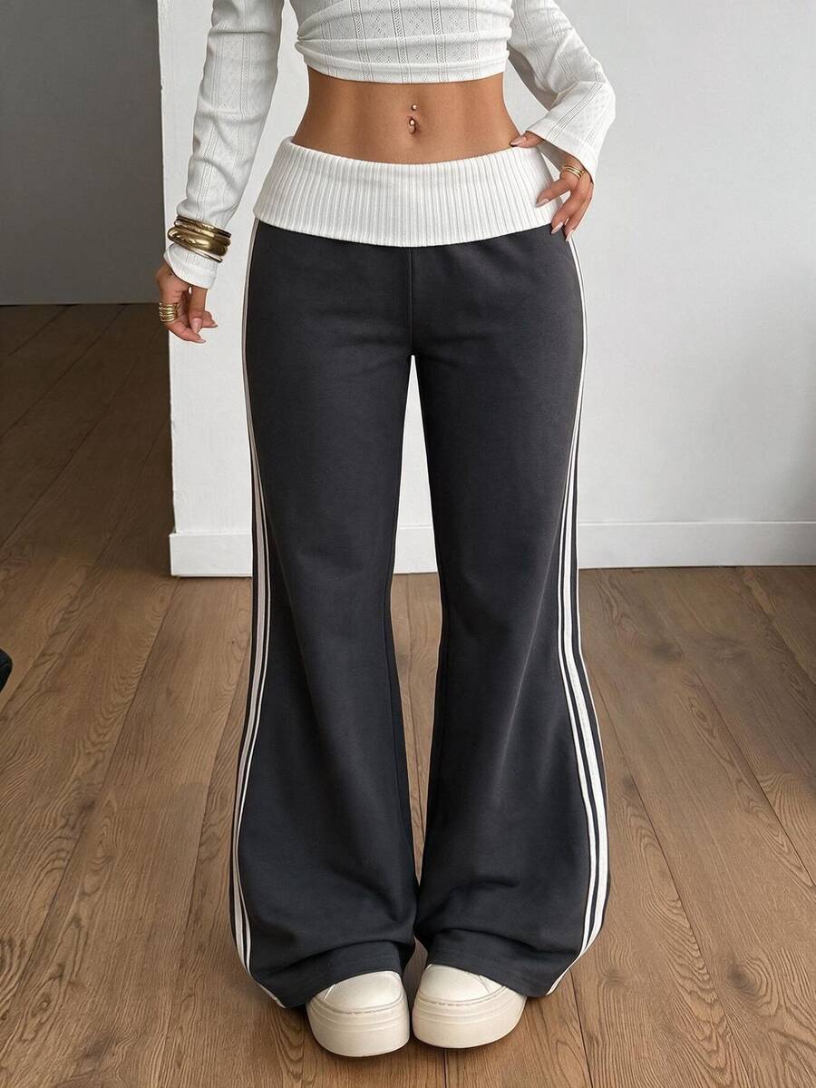 Women's wide leg flare sweatpants featuring a black and white colorblock contrast fold waistband and side stripe details.