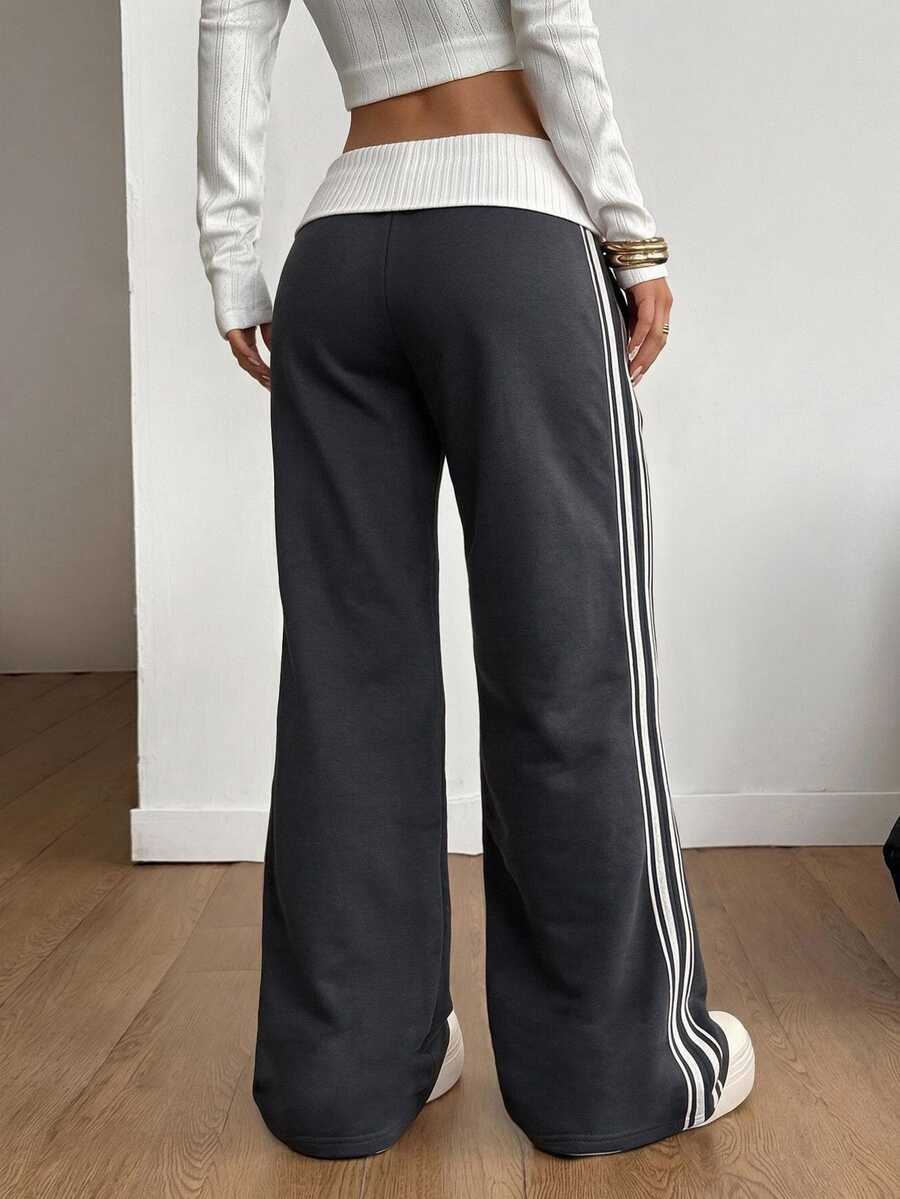 Women's wide leg flare sweatpants featuring a black and white colorblock contrast fold waistband and side stripe details.